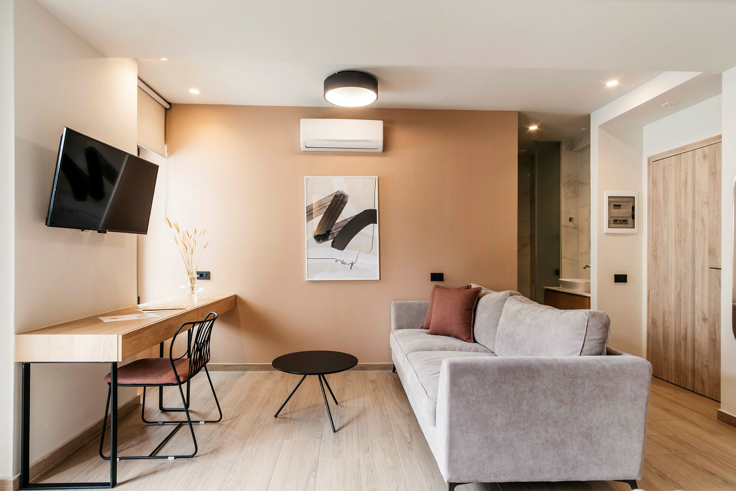Et moderne innredet stue med sofa, arbeidsbord og TV. (AI-generert tekst)