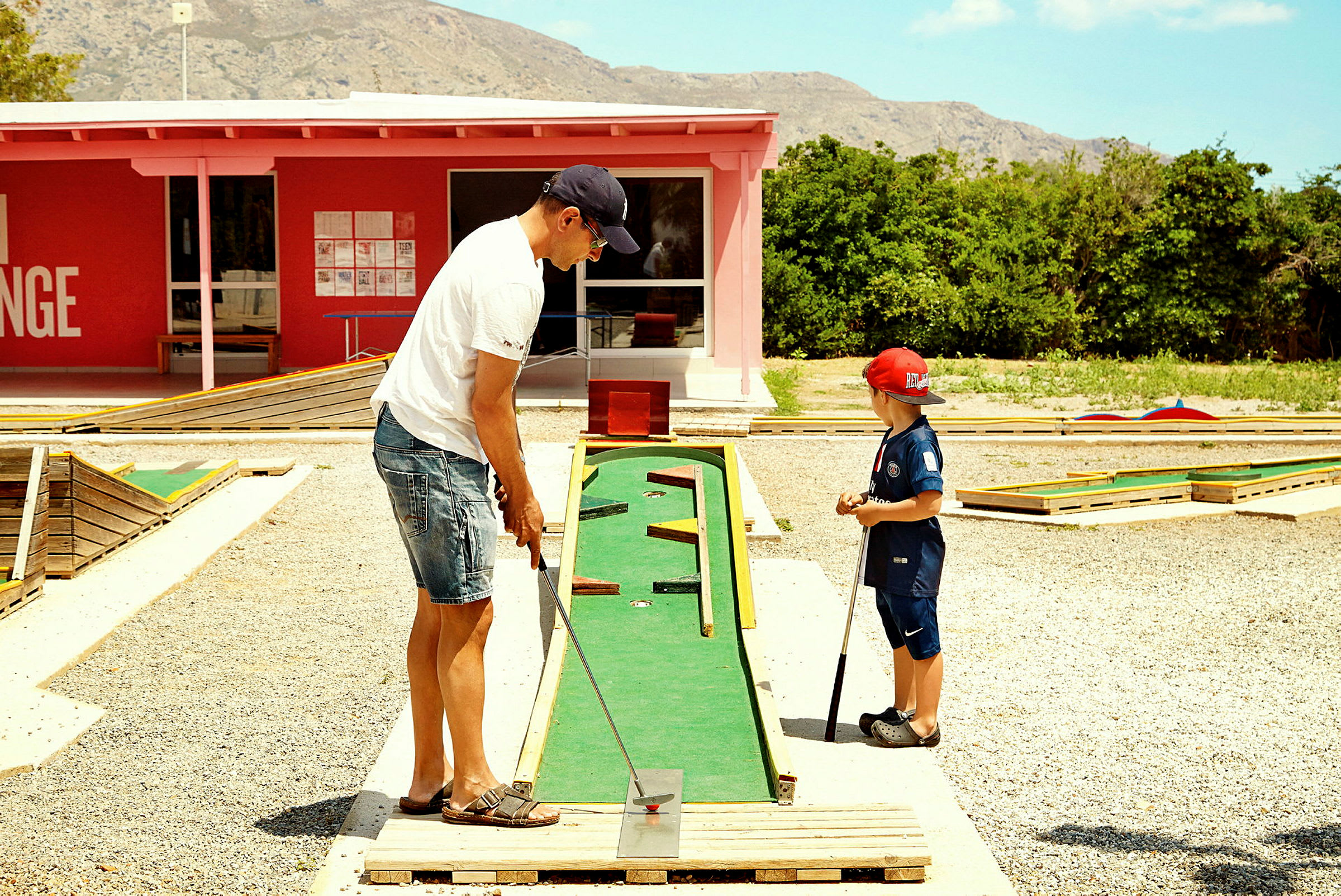 To personer spiller minigolf på en bane utendørs. (AI-generert tekst)