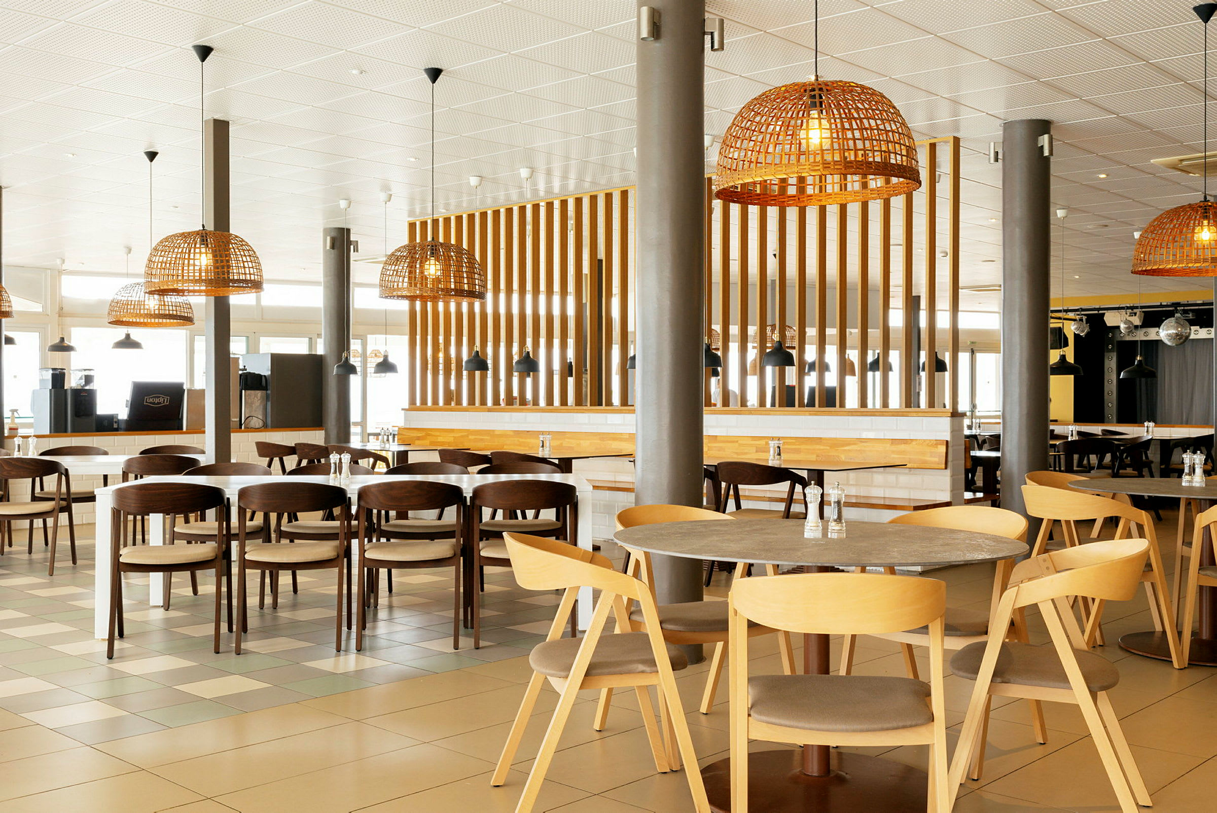 Bilde av en moderne restaurant med tremøbler og rottinglamper. (AI-generert tekst)