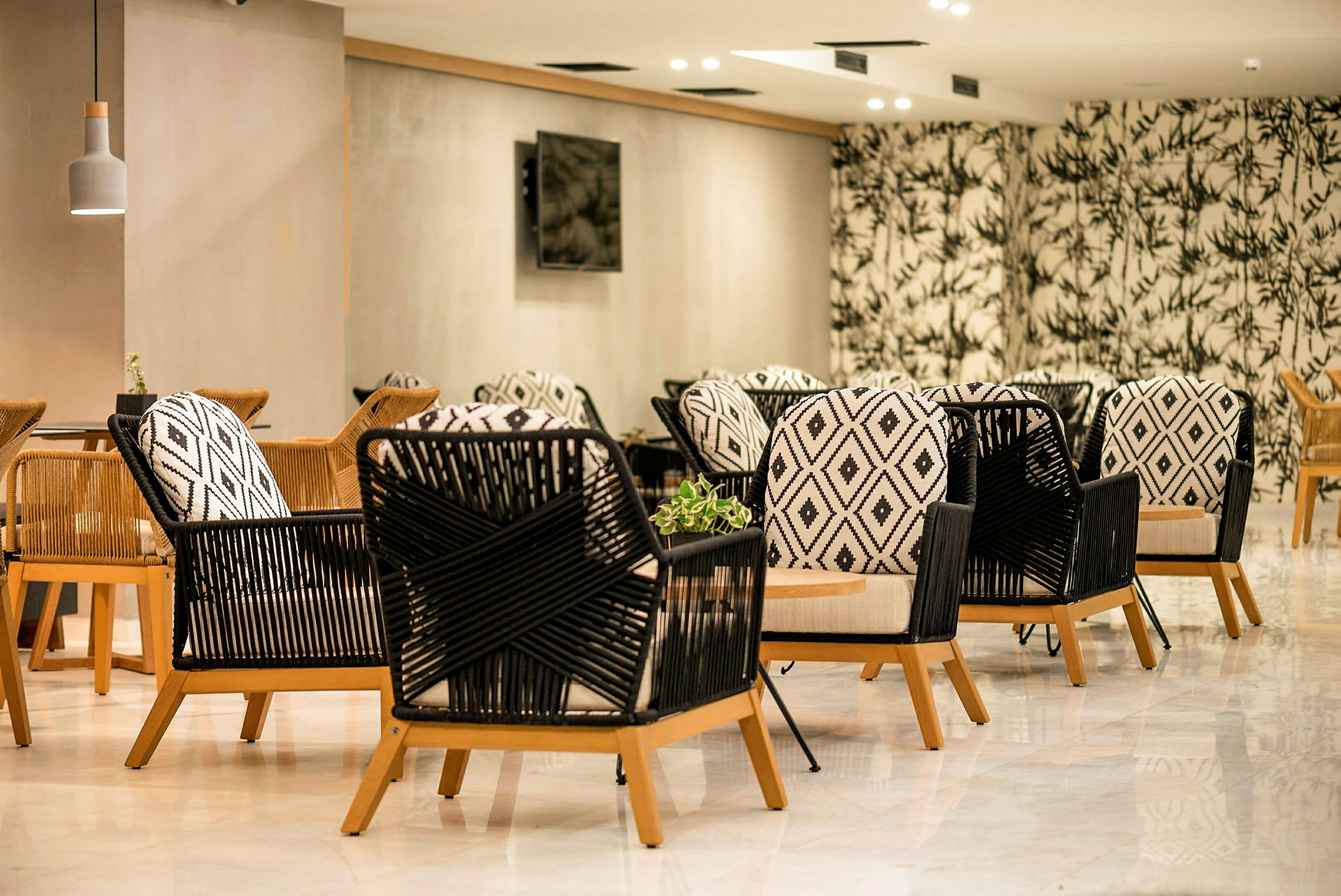 Bilde av sittegruppe med moderne stoler med geometriske mønstre og trebena, plassert i et rom med stilig interiør og dekorativ tapet. (AI-generert tekst)