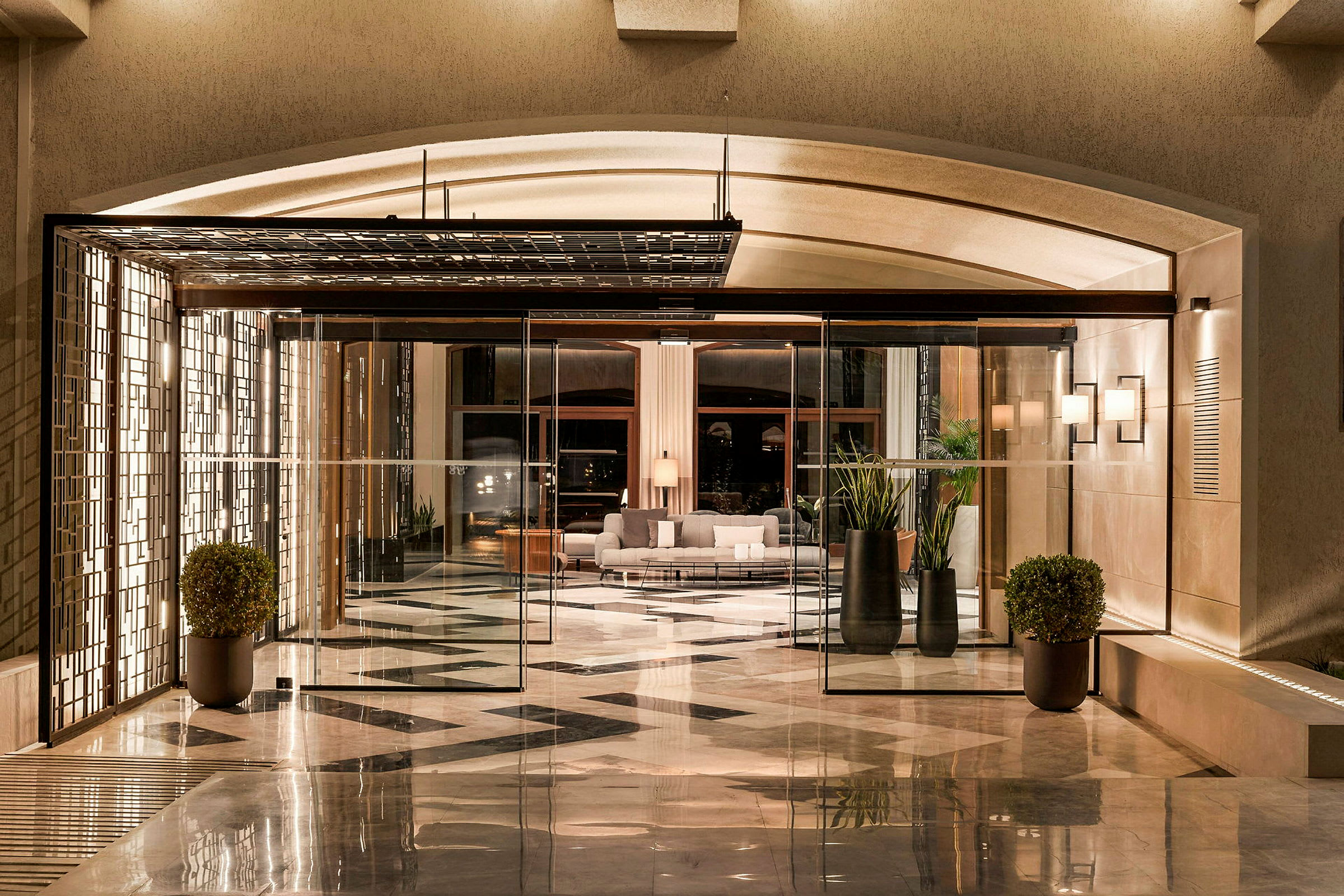 Bilde av en hotellobby med glassdører, moderne møbler og marmorgulvdesign. (AI-generert tekst)