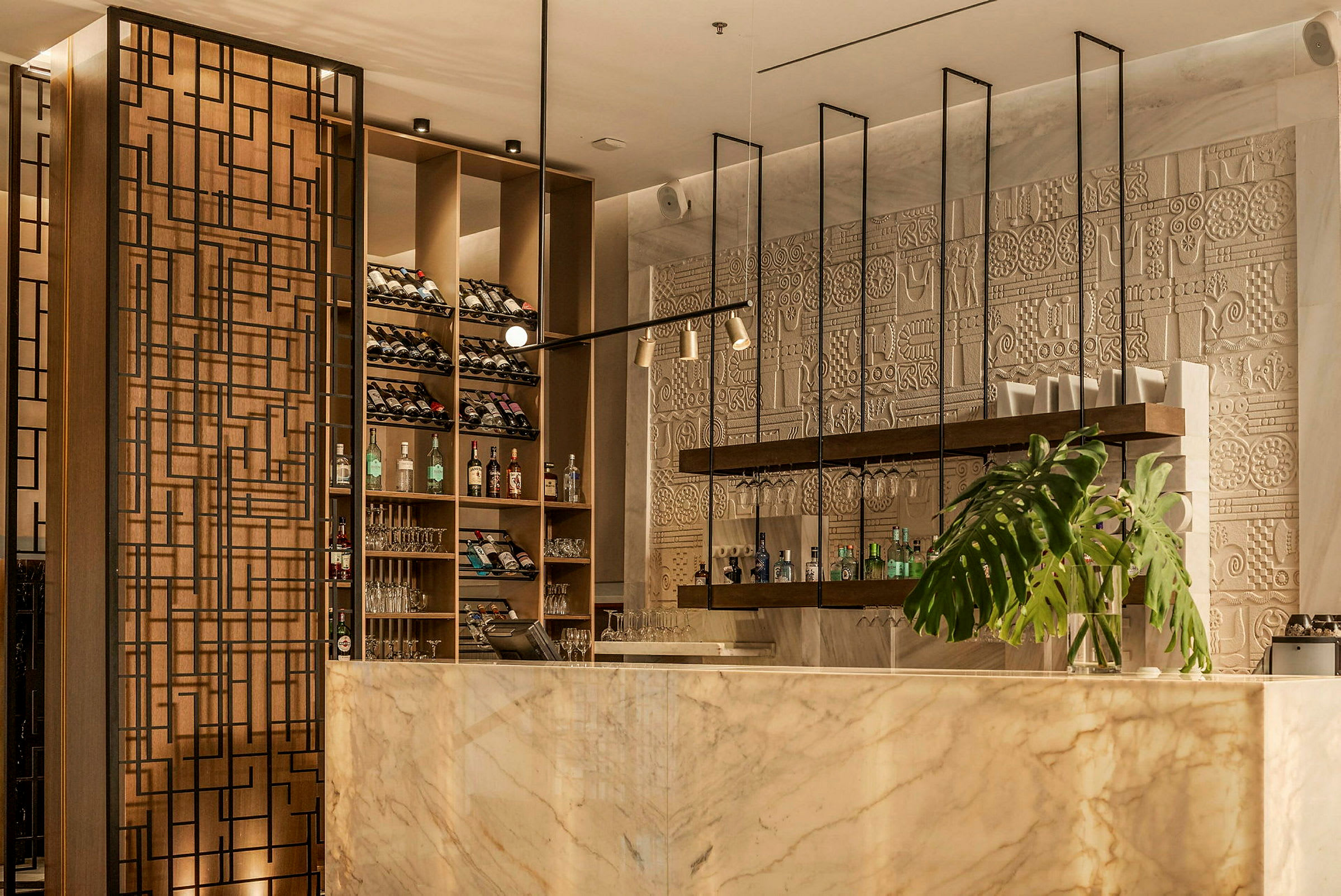 Elegant bar med marmordisk, vinhyller, dekorativ vegg og plante. (AI-generert tekst)