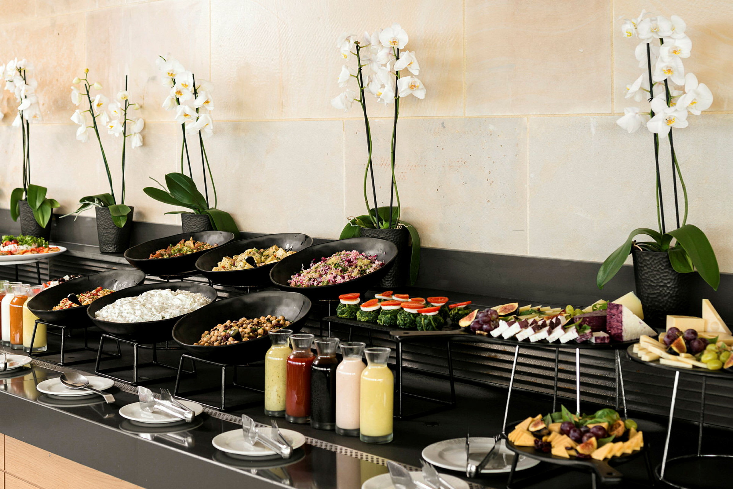 En buffet med forskjellige retter og drikker, dekorert med hvite orkideer. (AI-generert tekst)