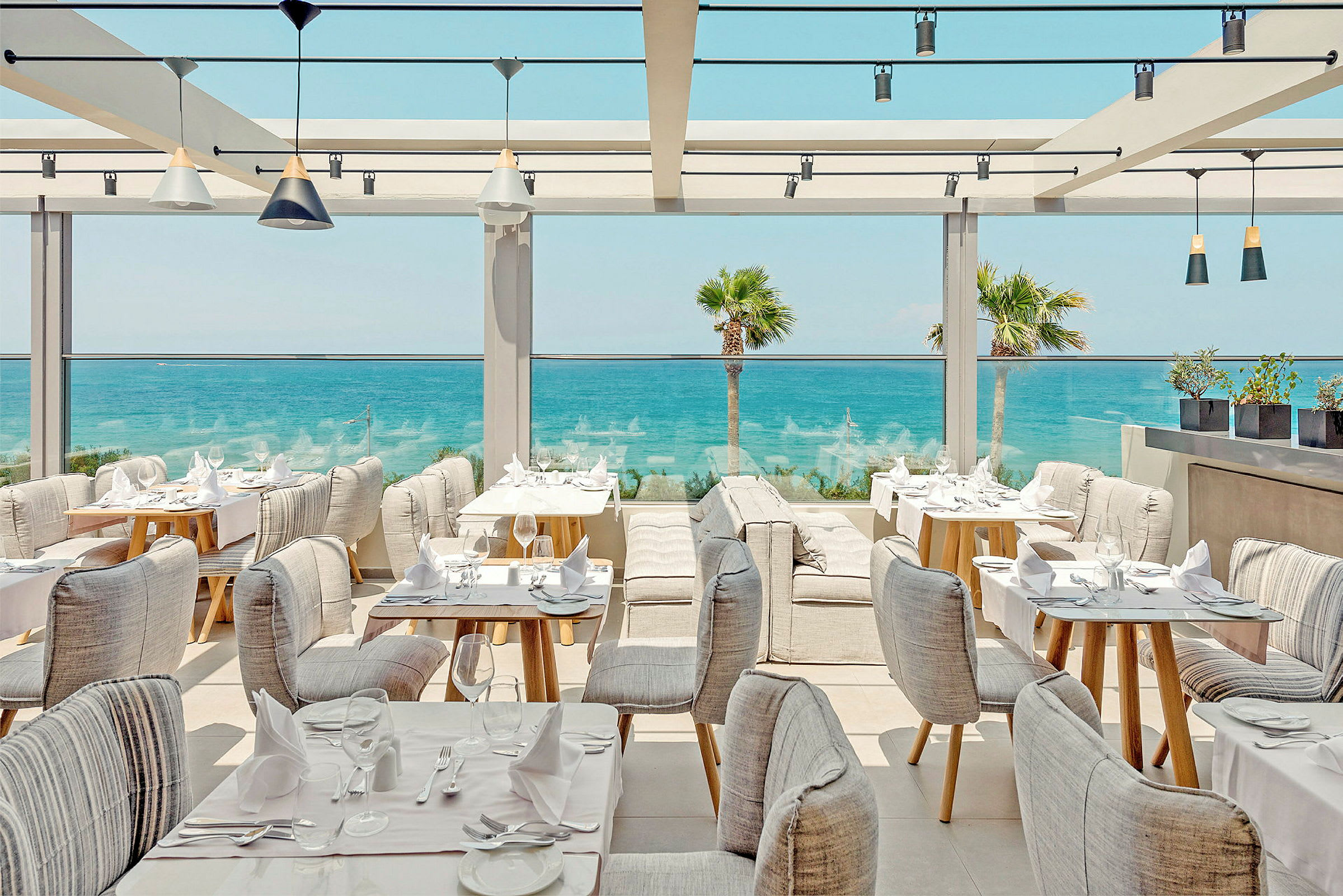 En restaurant med sitteplasser ved havet. (AI-generert tekst)