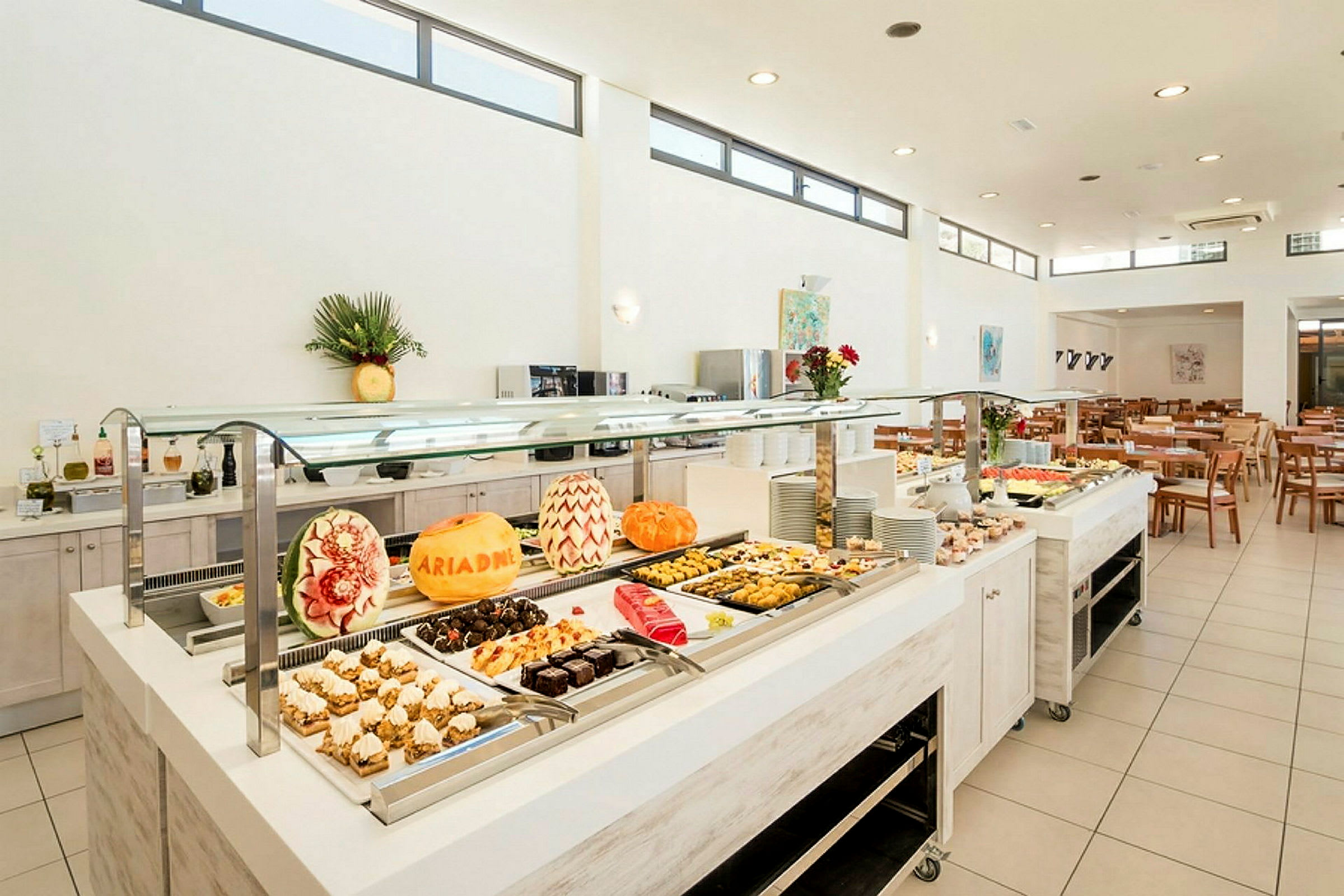 Buffet med dekorerte meloner og et utvalg av desserter. (AI-generert tekst)