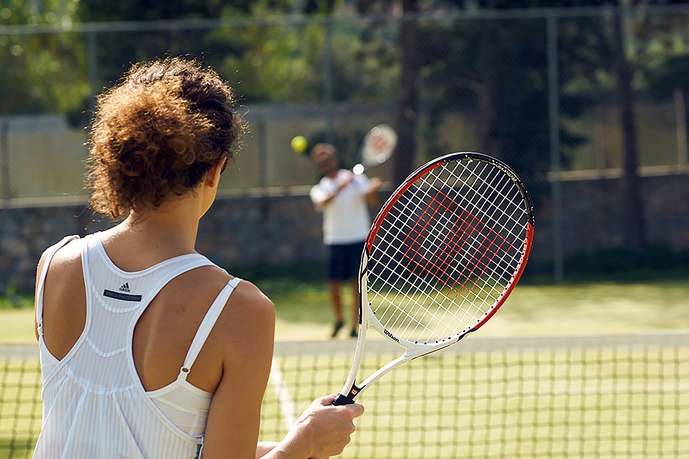 Person holder en tennisracket på en tennisbane. (AI-generert tekst)