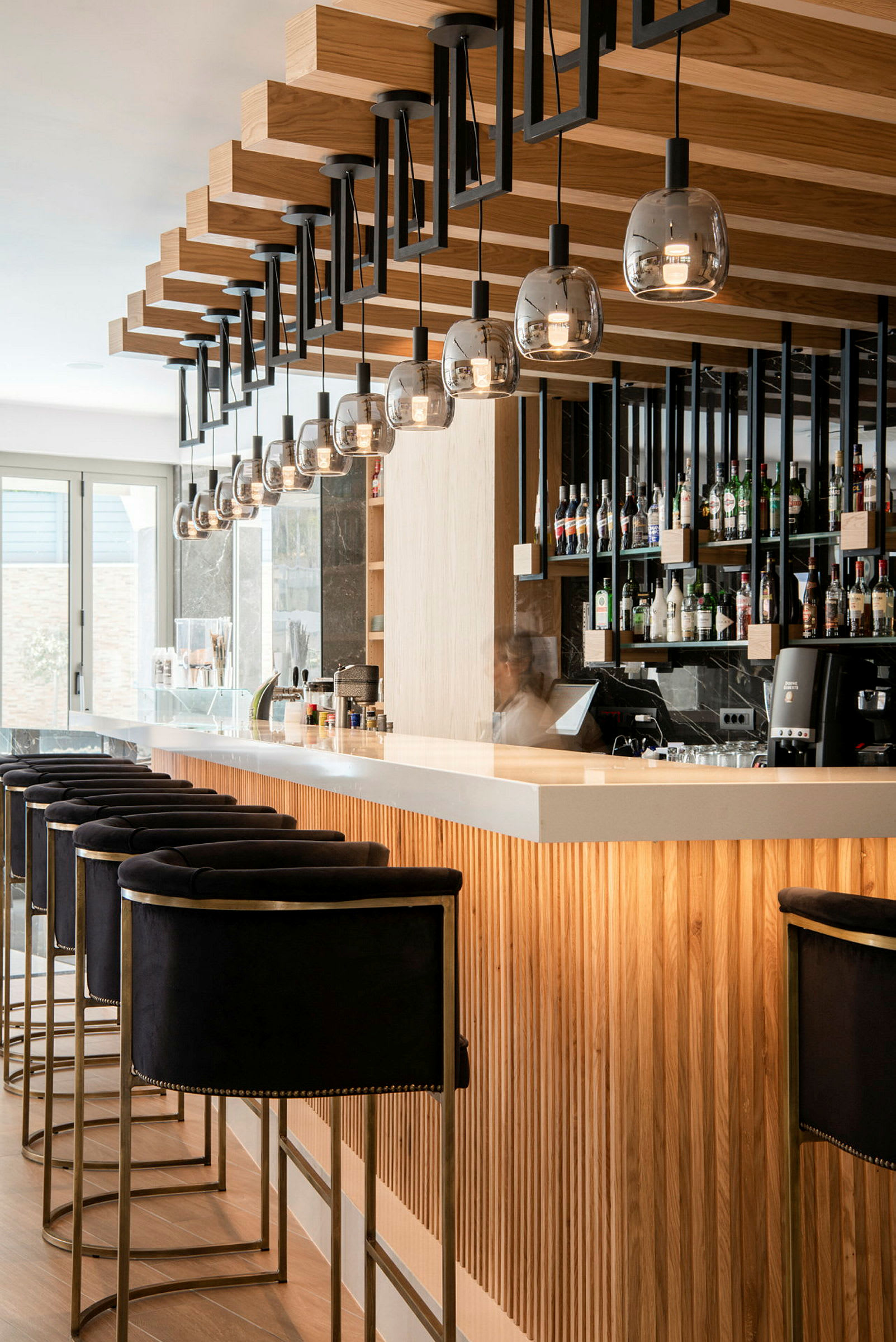 Moderne hotellbar med sitteplasser og hyller med flasker. (AI-generert tekst)