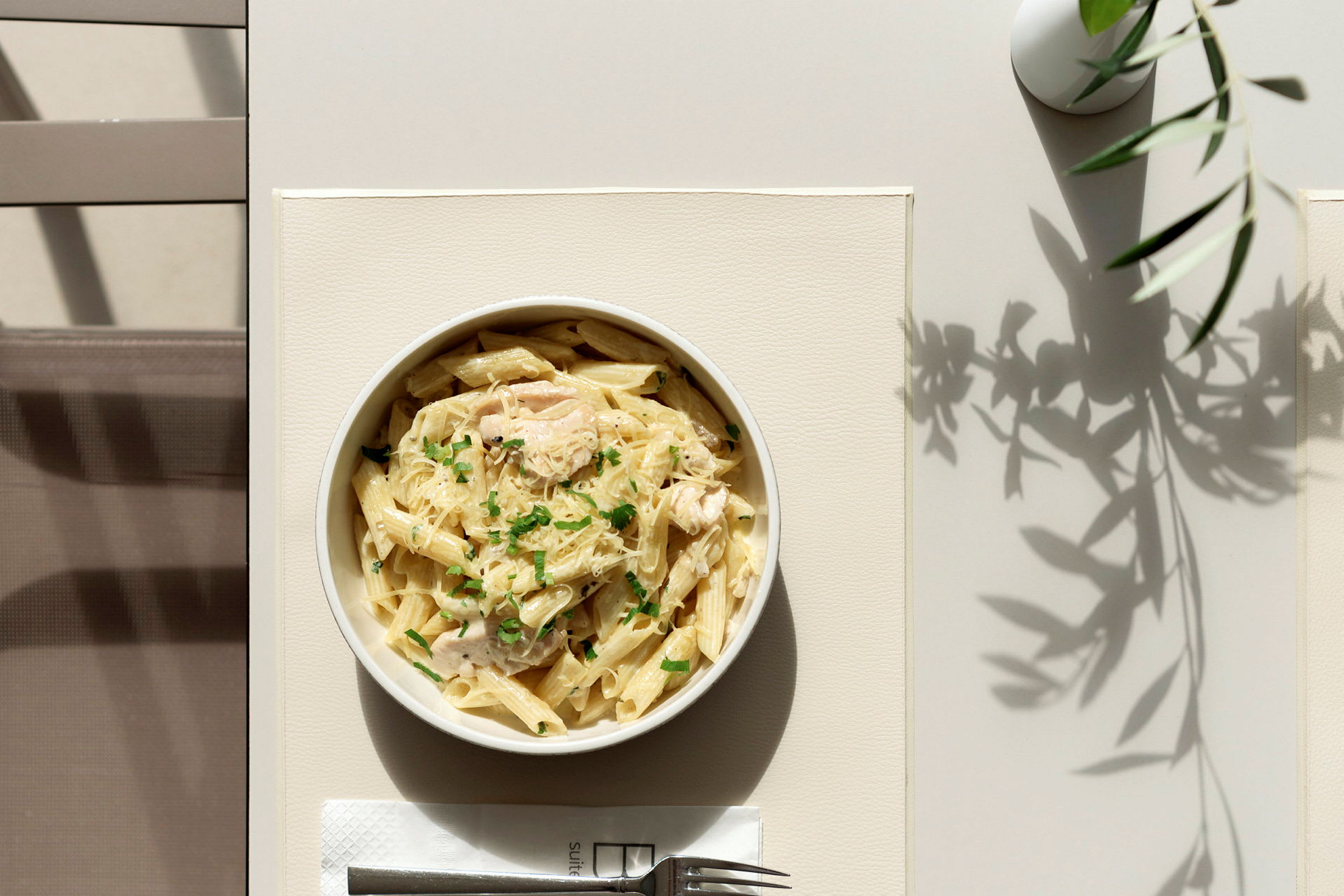 En tallerken med pasta servert på et bord. (AI-generert tekst)