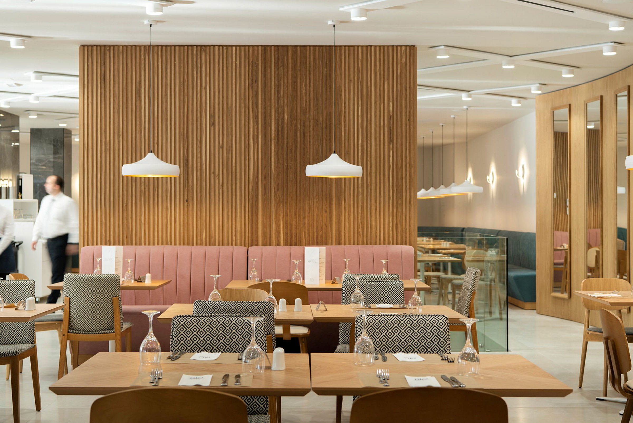 Restaurant med bord og stoler samt dekorative lamper. (AI-generert tekst)