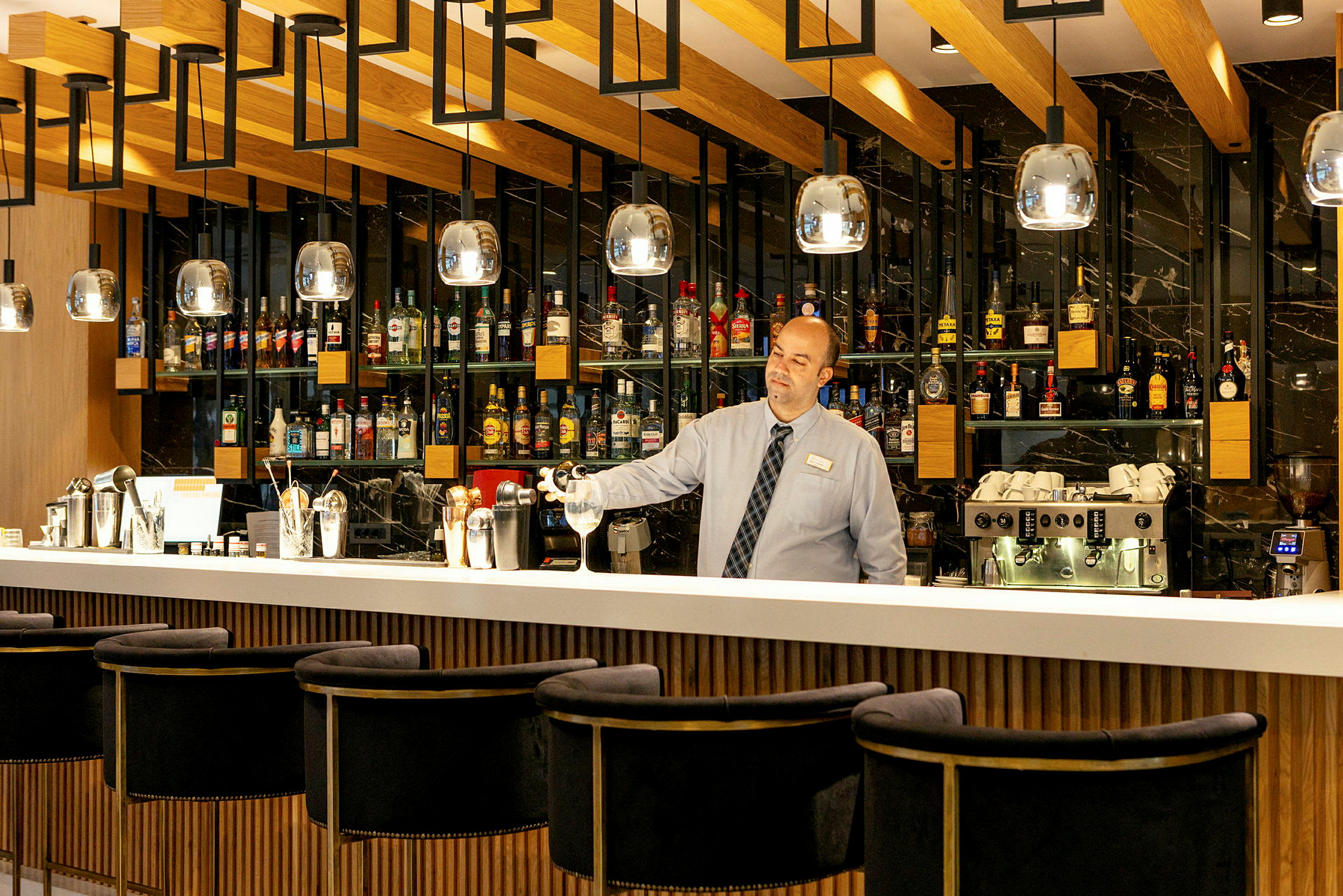 En bartender står bak en fullt utstyrt bar. (AI-generert tekst)