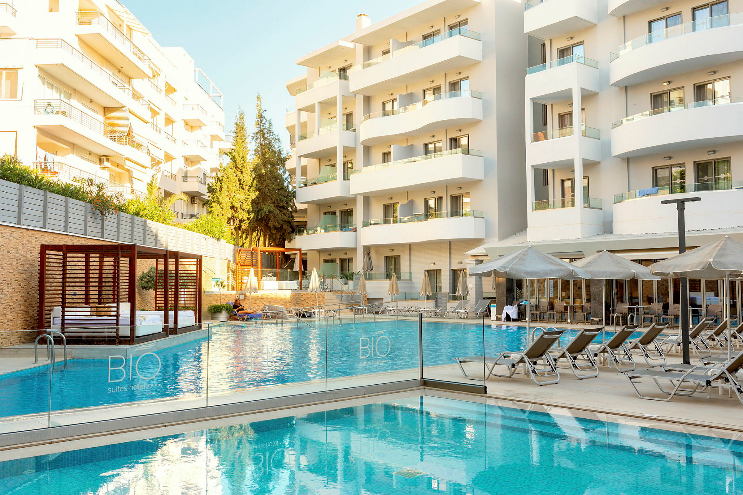 Bilde av et hotell med et utendørsbasseng og solsenger foran bygningen. (AI-generert tekst)