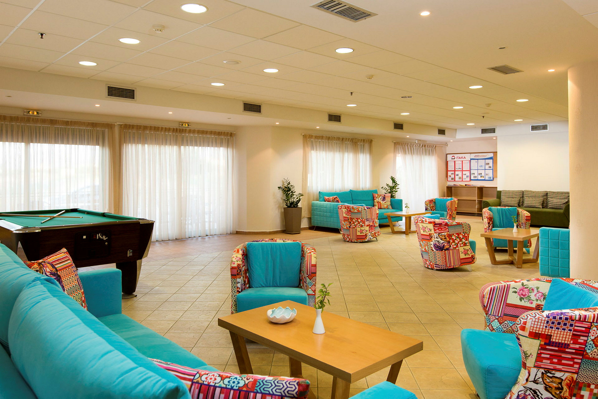 Hotellobby med sitteplasser og biljardbord. (AI-generert tekst)