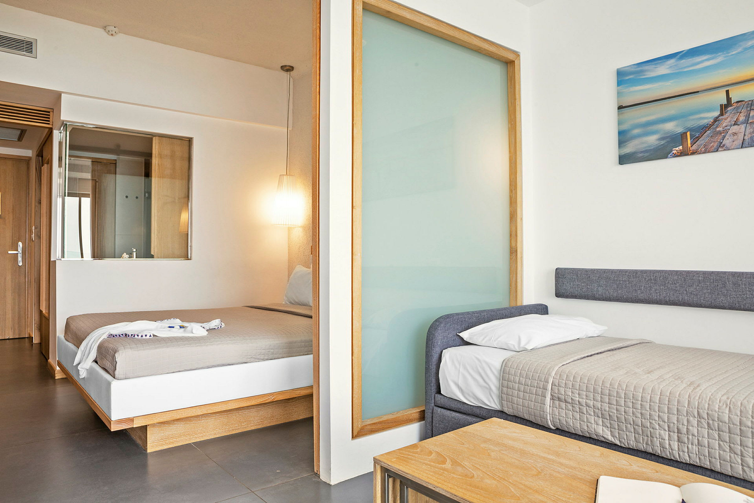 Et hotellrom med to senger, en dobbeltseng og en enkeltseng. (AI-generert tekst)