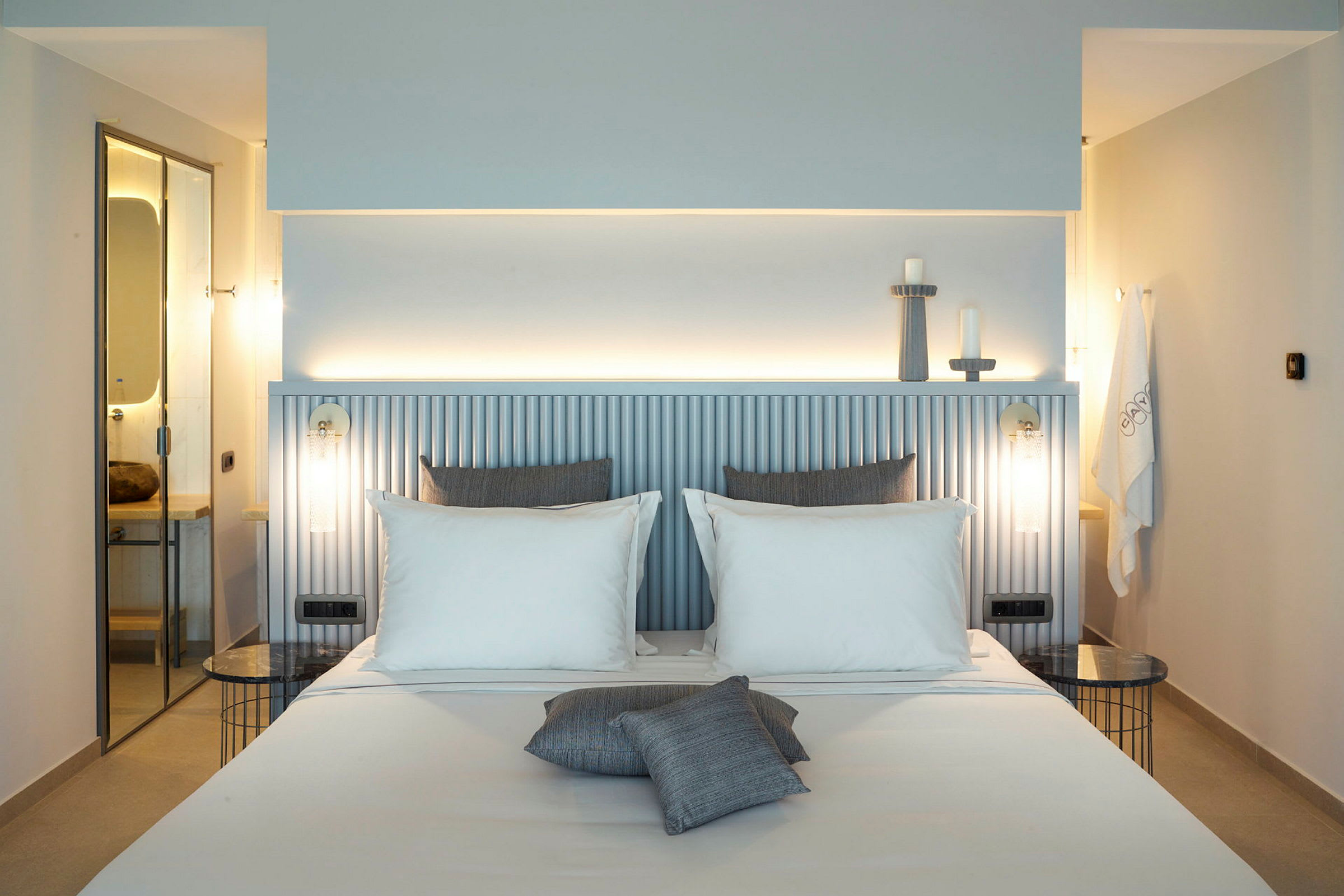 Et stilrent hotellrom med en dobbeltseng og moderne detaljer. (AI-generert tekst)