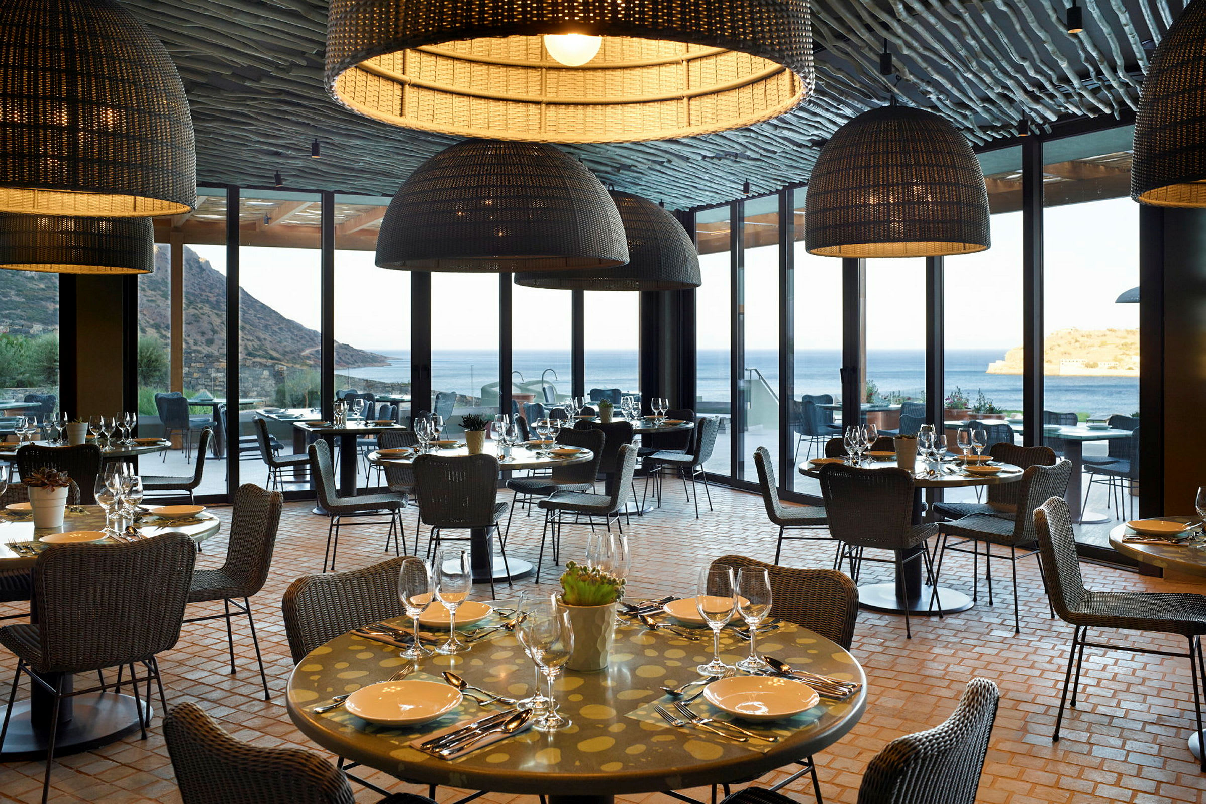 En restaurant med dekkede bord som ligger med utsikt over havet. (AI-generert tekst)