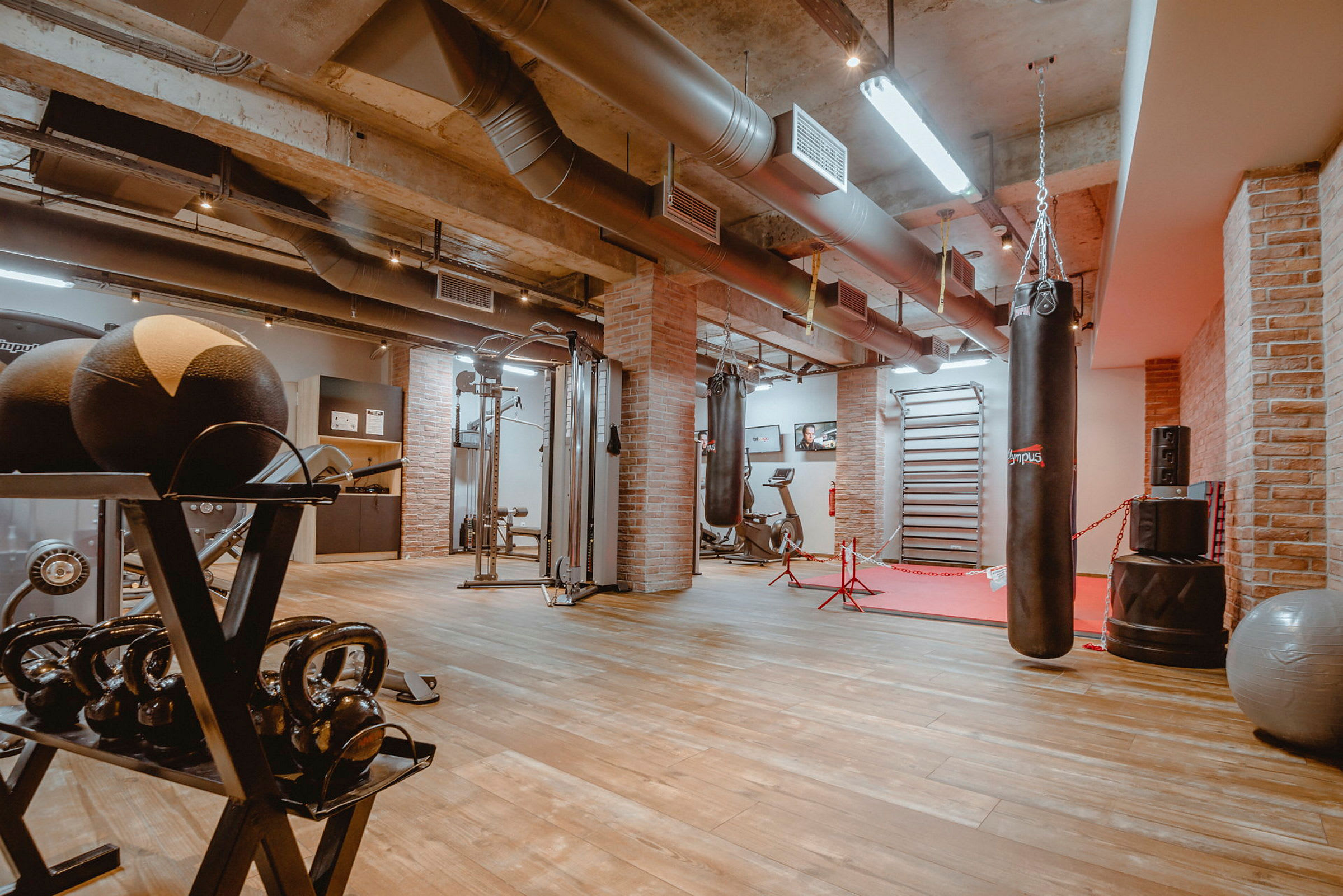 Gym med treningsutstyr, boksesekk og vekter. (AI-generert tekst)