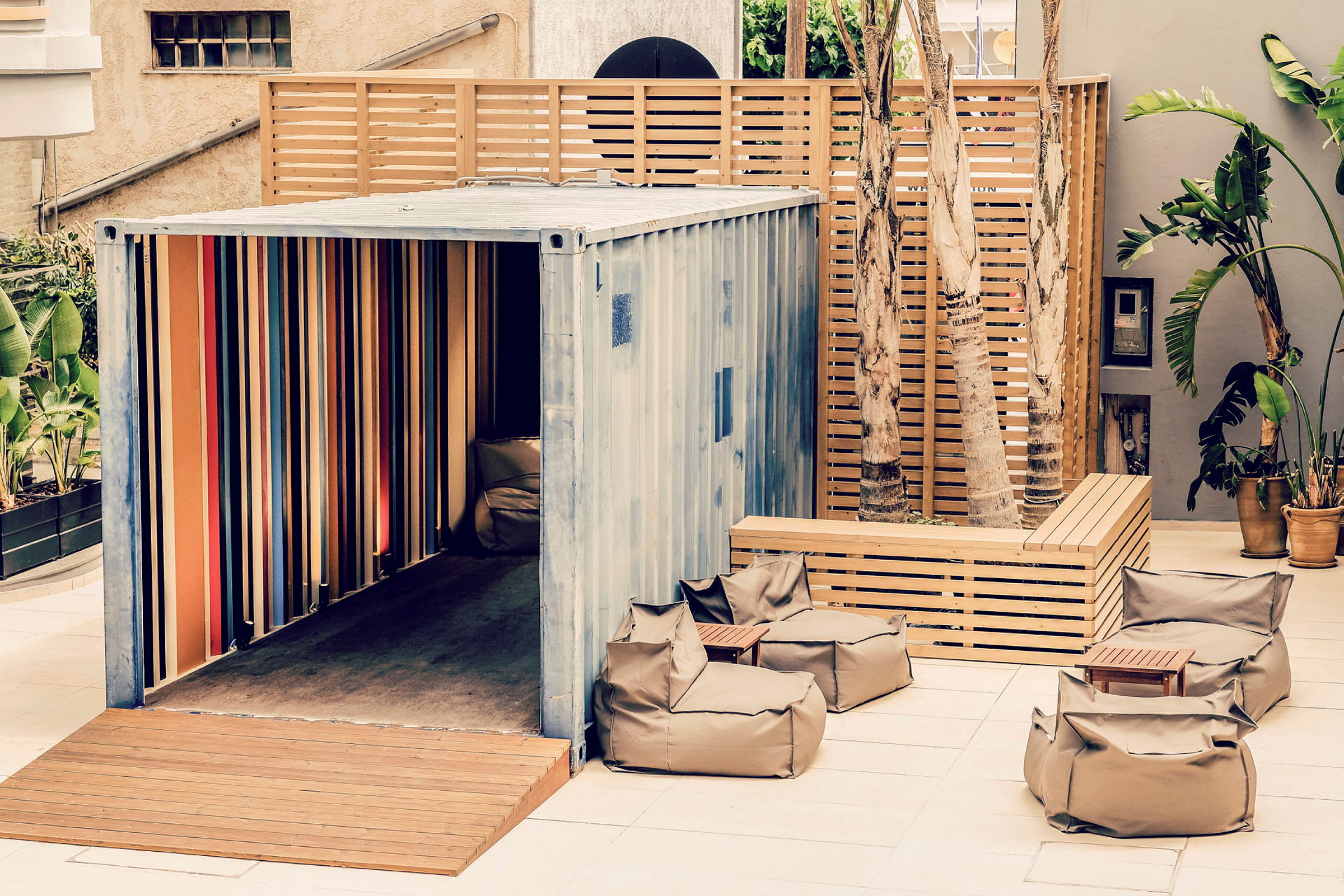 Utendørsområde med shippingcontainer, sittesekker og trekledning. (AI-generert tekst)