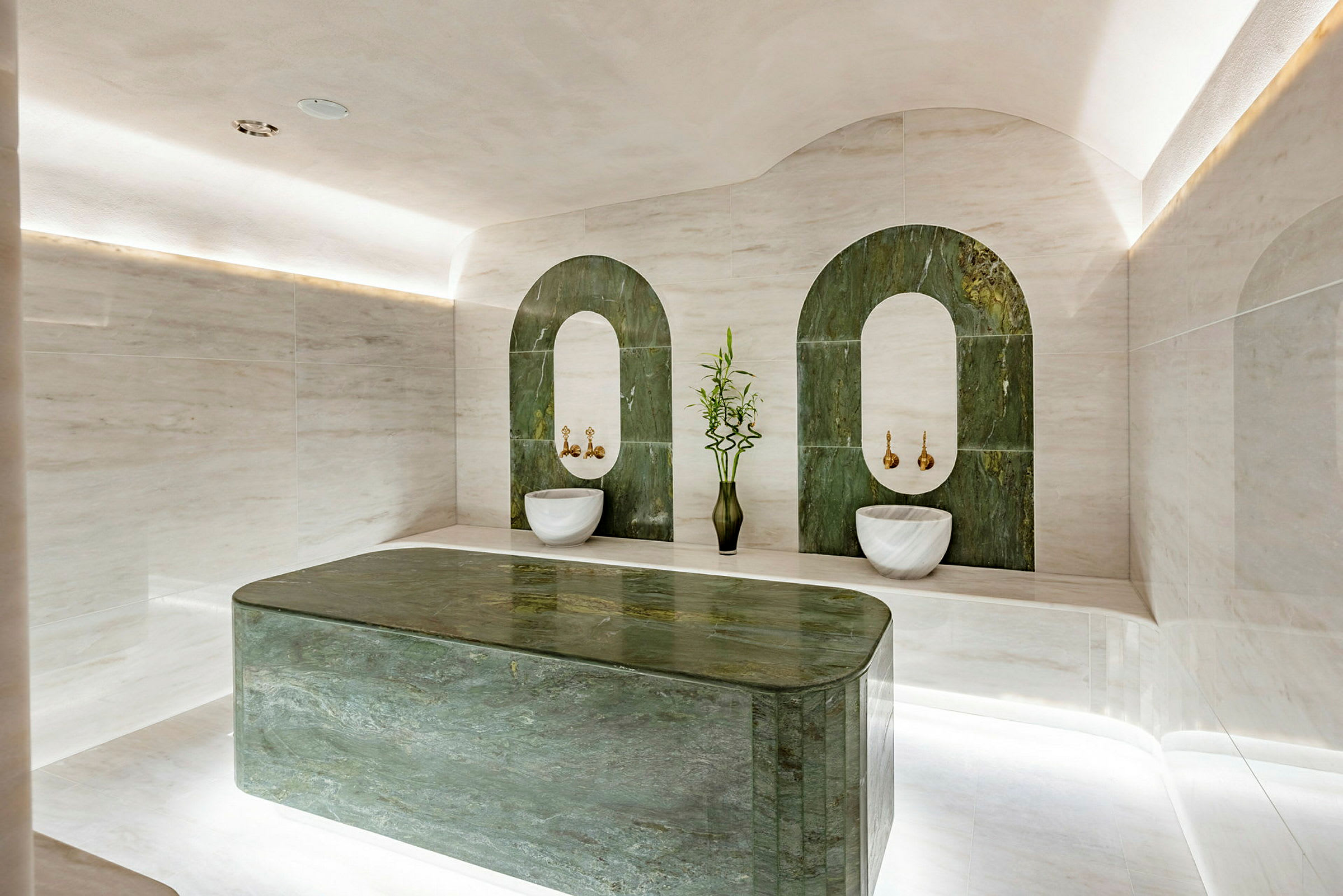 Bilde av et elegant hamam med grønne marmordekorasjoner og hvite steinmaterialer. (AI-generert tekst)