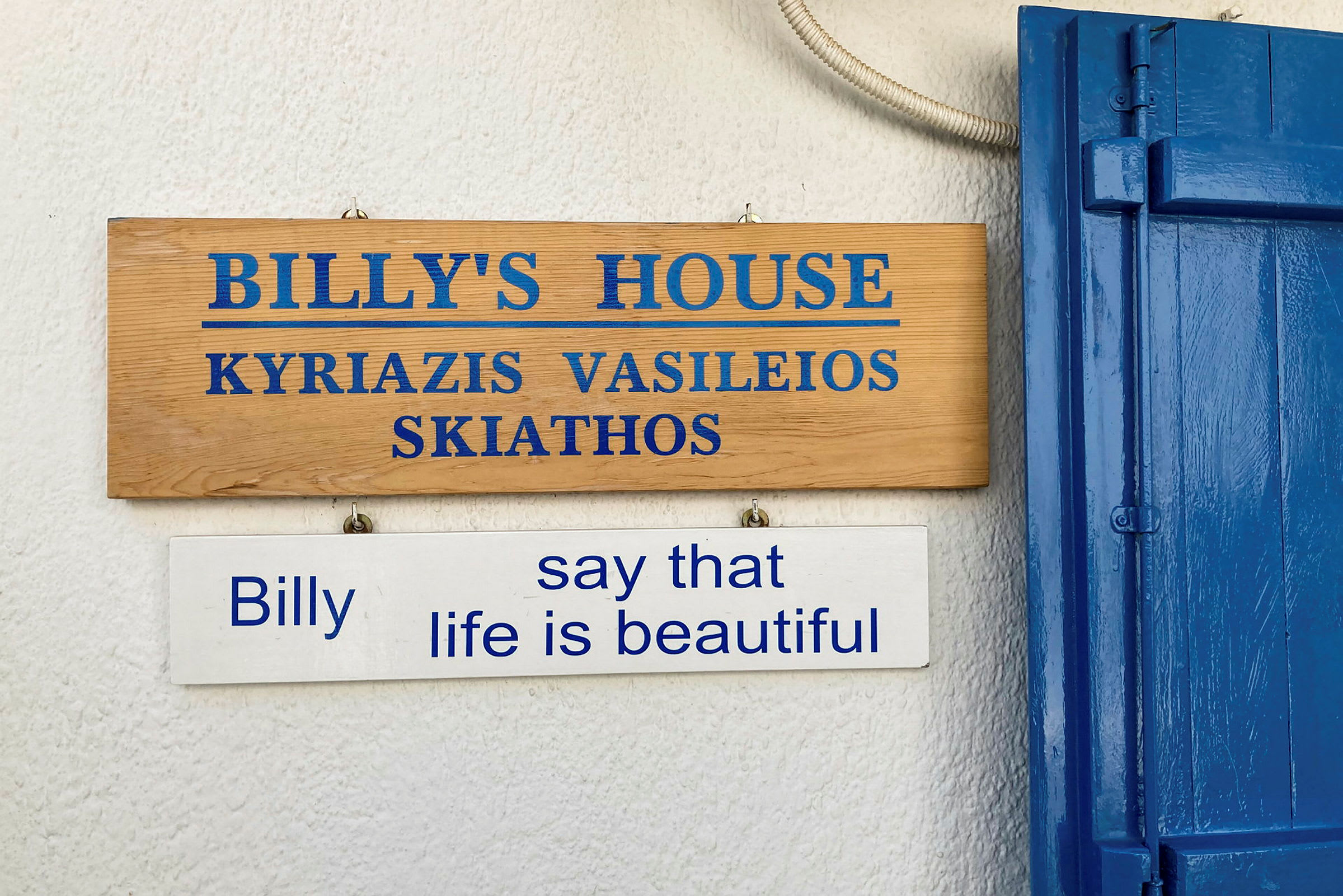 Treskilt som markerer 'Billy's House' og et hvitt skilt under som sier "Billy say that life is beautiful". (AI-generert tekst)
