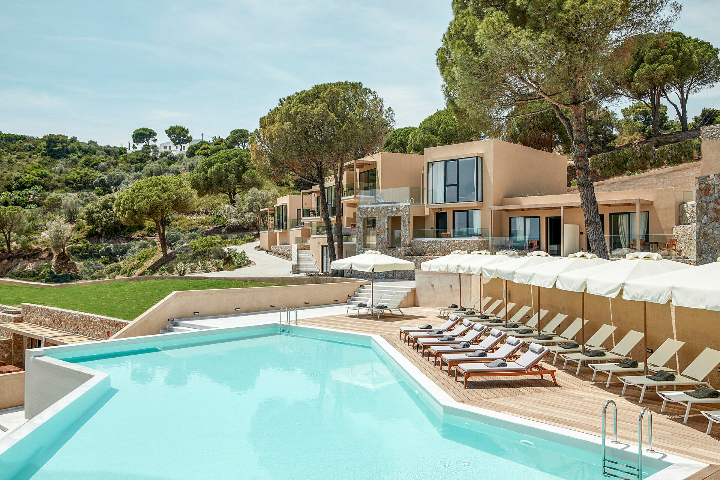 Bassengområde ved en moderne resort omgitt av frodig natur. (AI-generert tekst)