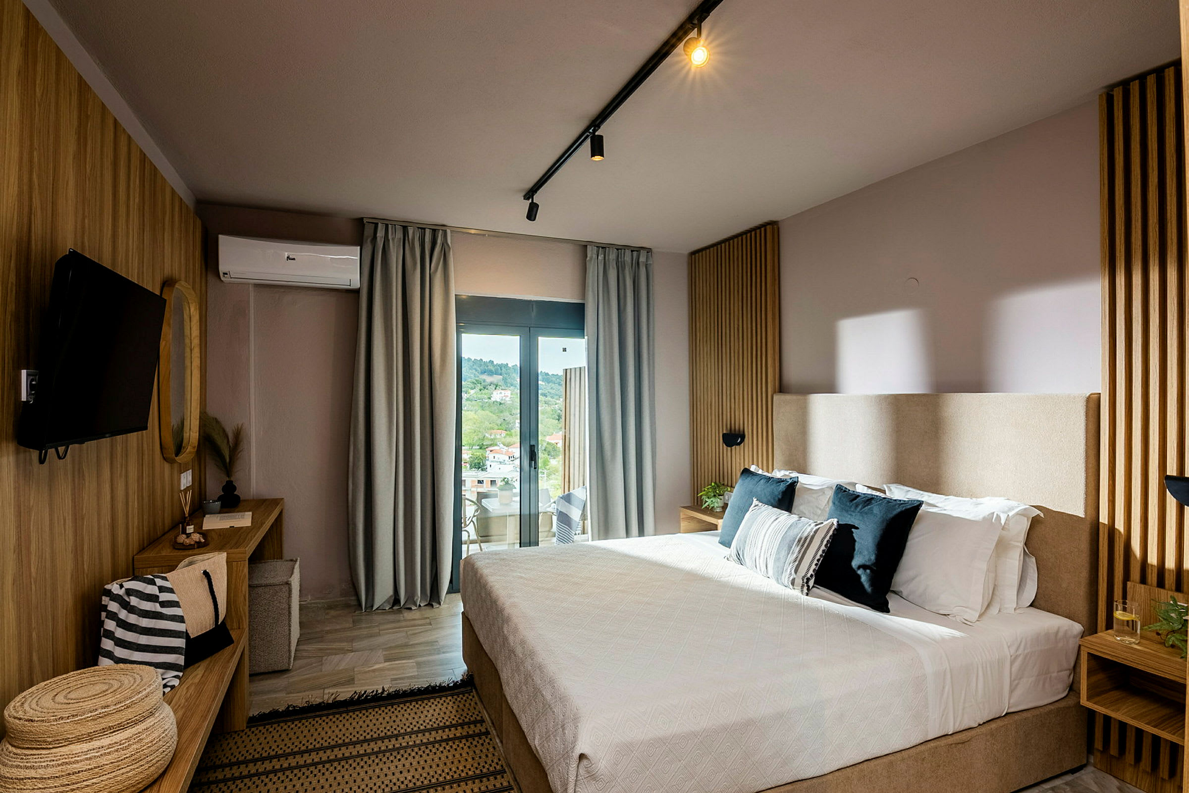Et moderne hotellrom med seng, skrivebord og stort vindu med utsikt. (AI-generert tekst)