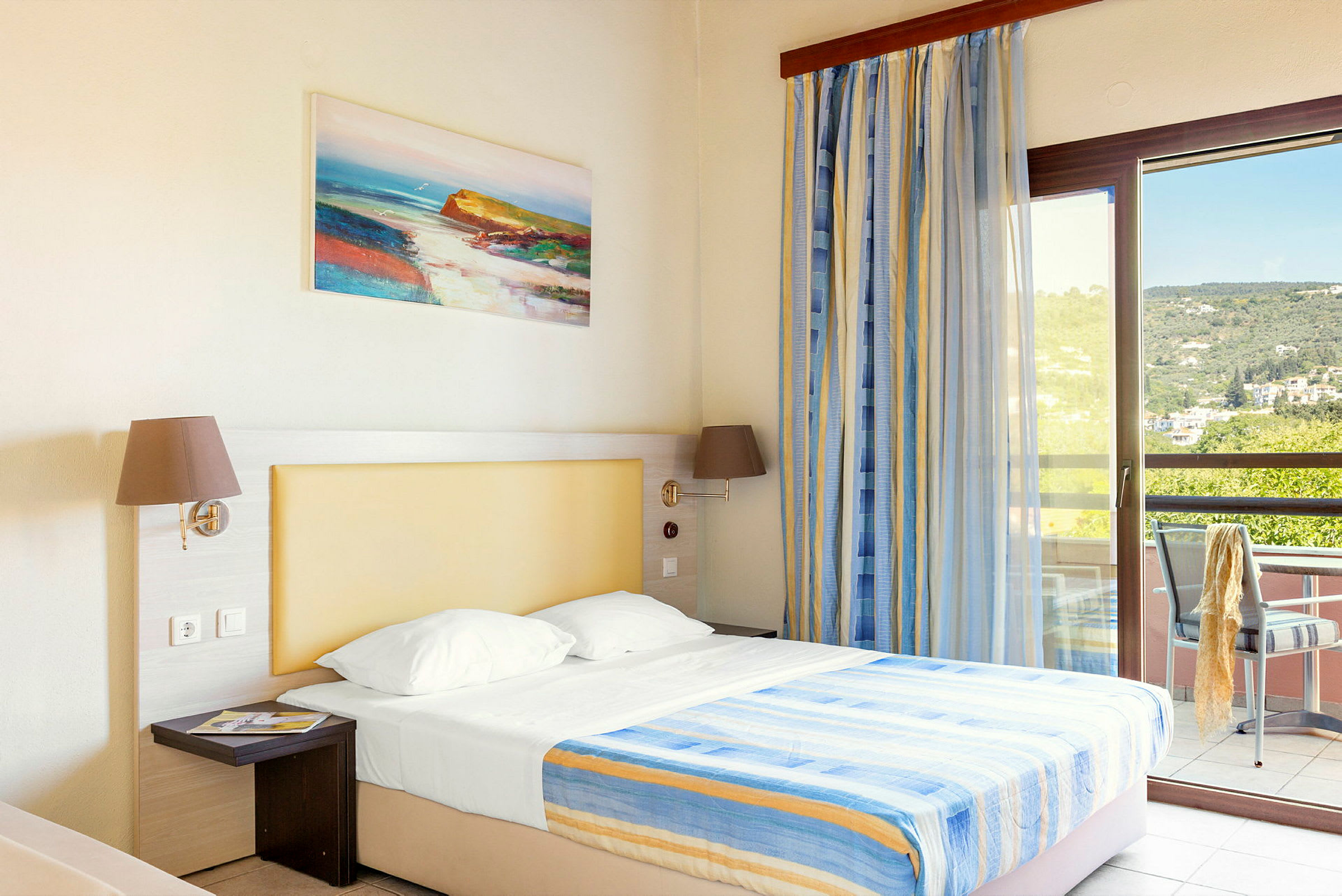 Et hotellrom med en seng, opplyst med naturlig lys fra en balkong. (AI-generert tekst)