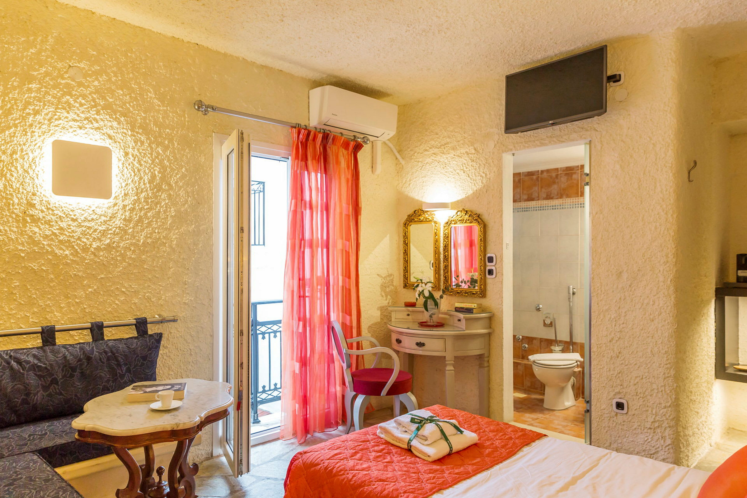 Et hotellrom med en seng, et skrivebord med speil og en inngang til badet. (AI-generert tekst)