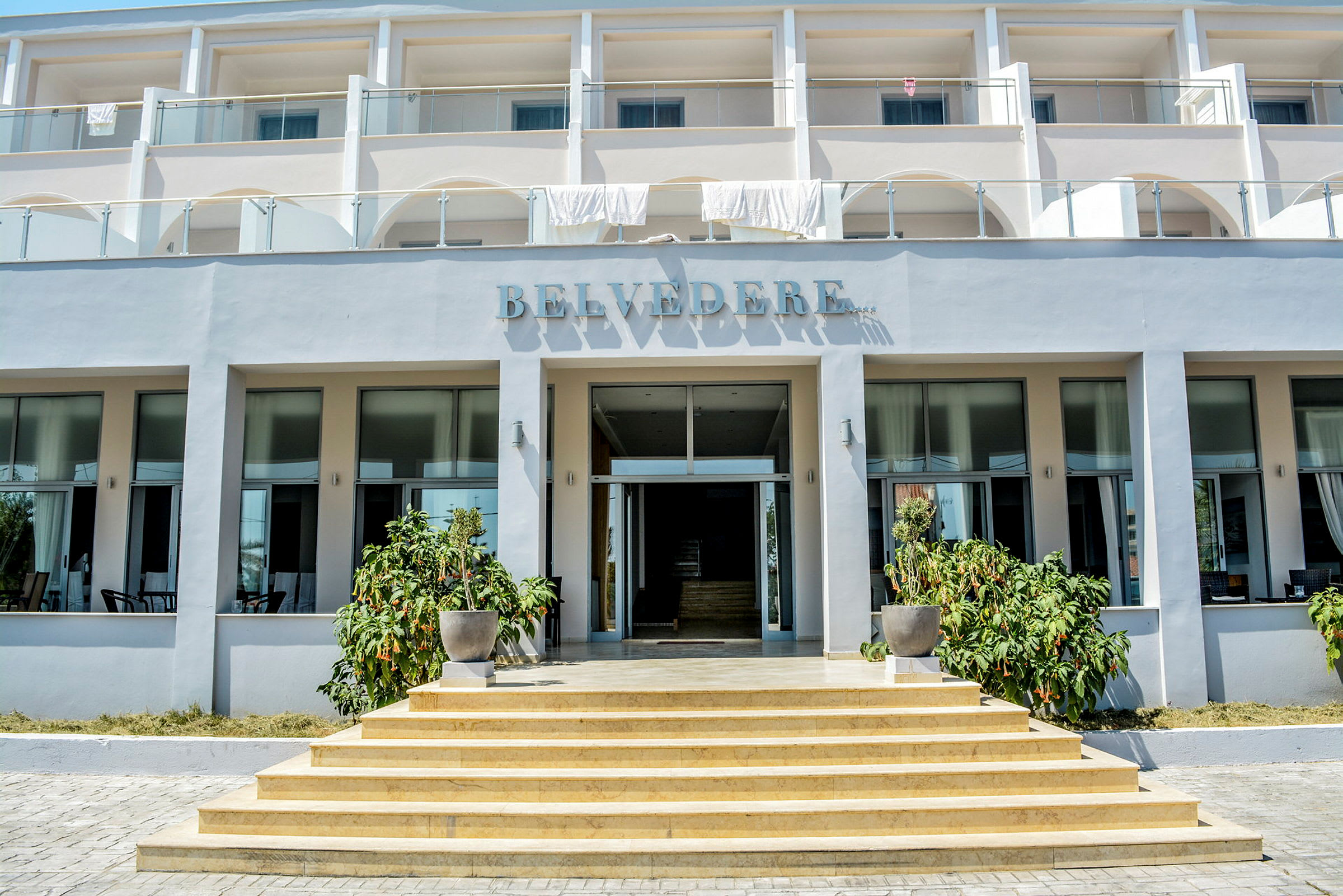 Hotellbygning med tre etasjer, navnet 'Belvedere' synlig over inngangen. (AI-generert tekst)