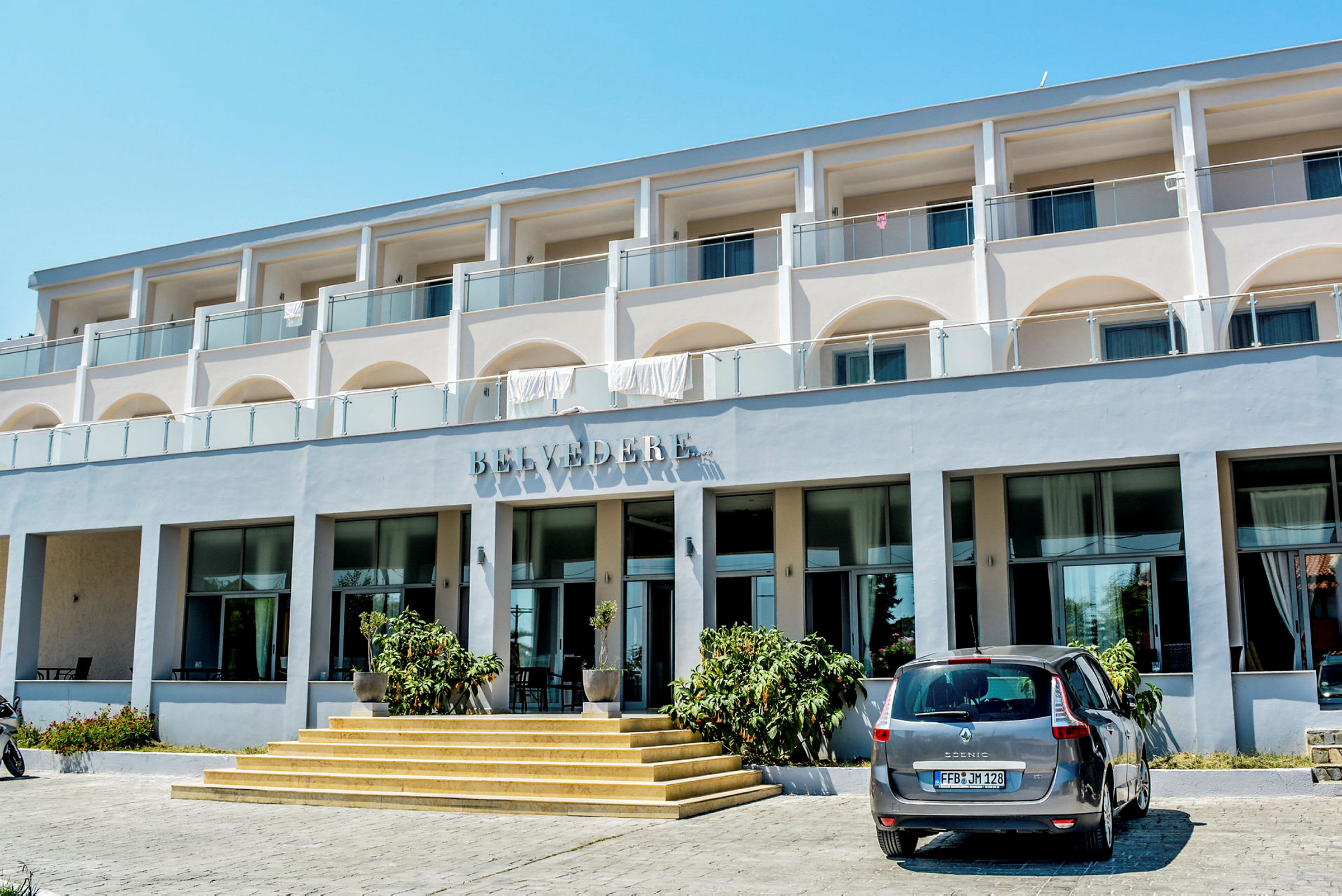 Eksteriør av hotellbygningen Belvedere med bil parkert foran inngangen. (AI-generert tekst)