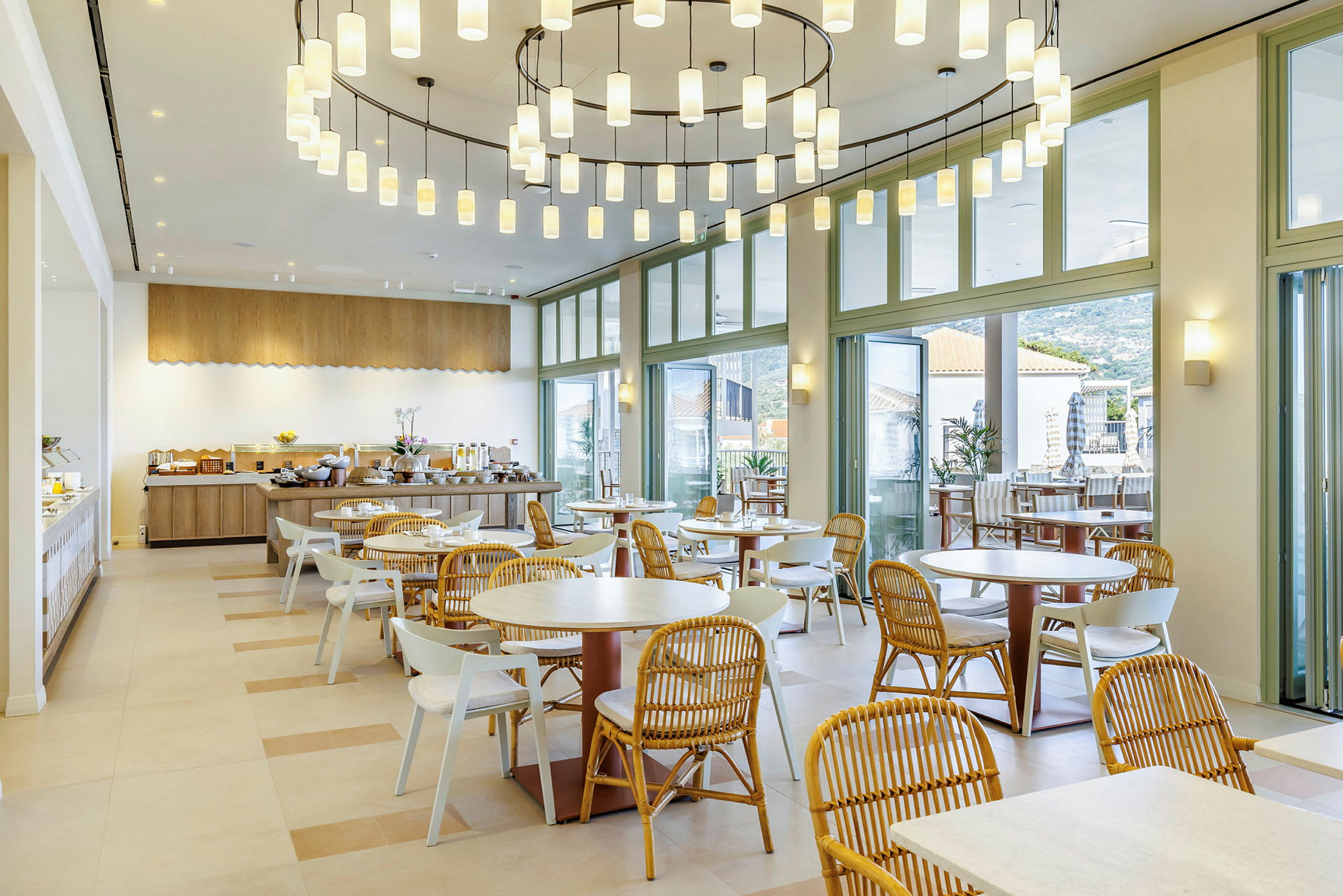 En moderne restaurant med store vinduer og runde bord og stoler. (AI-generert tekst)