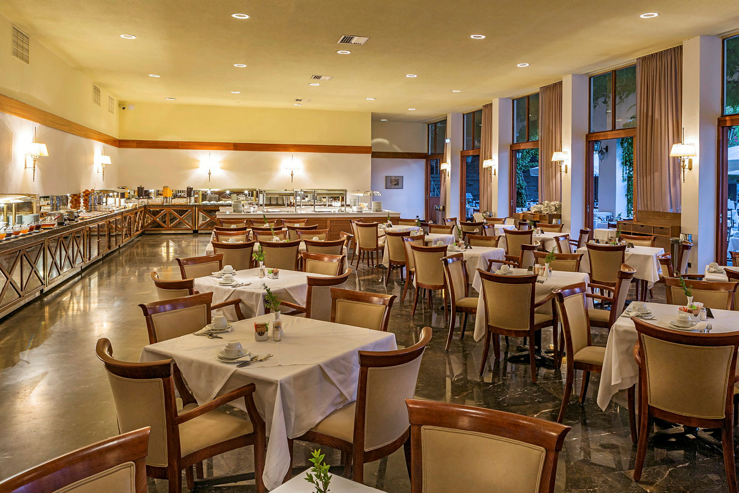 Bilde av en restaurant med bord dekket og et buffetområde. (AI-generert tekst)
