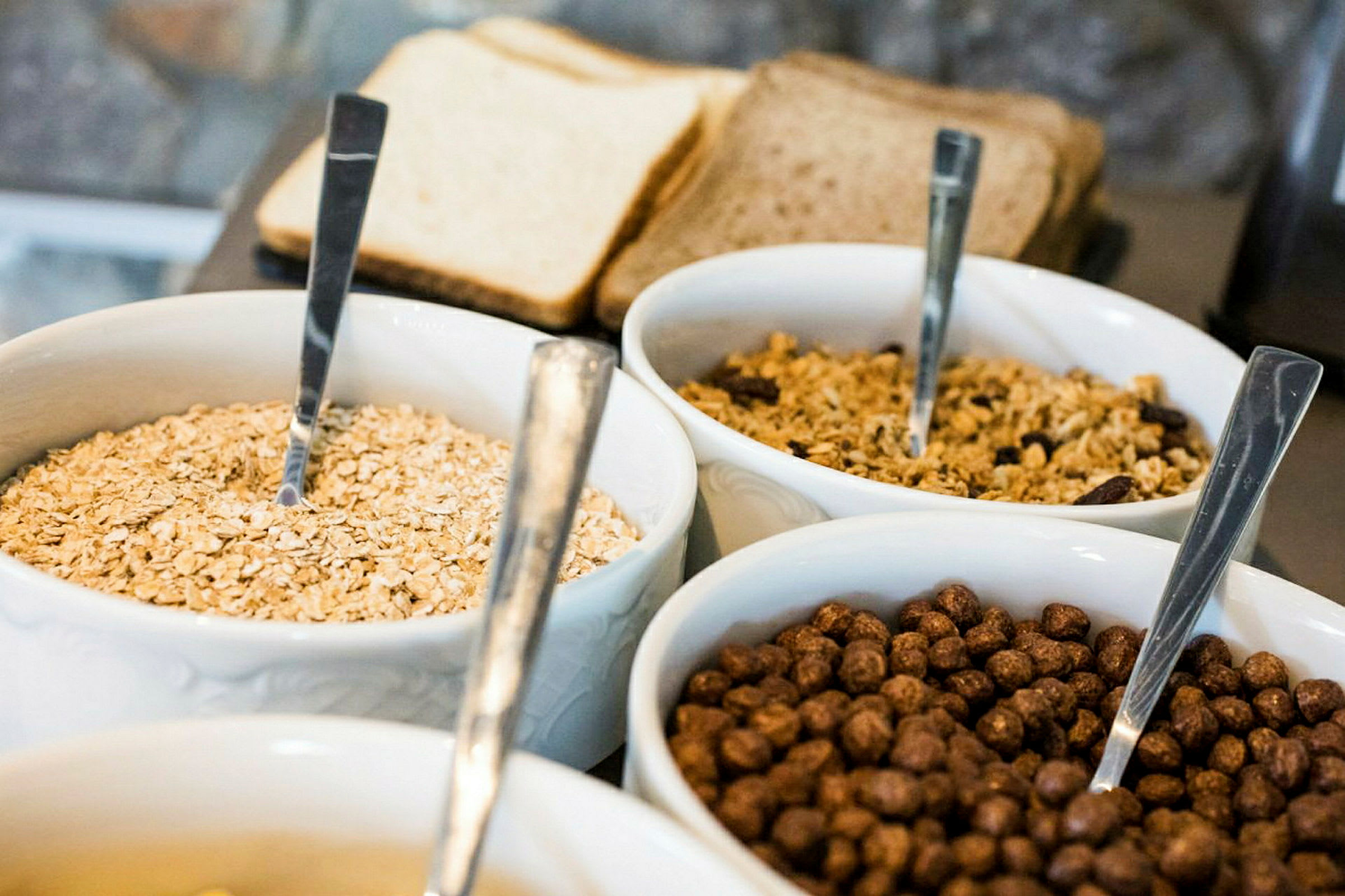 Boller med forskjellige typer frokostblanding og brød i bakgrunnen. (AI-generert tekst)