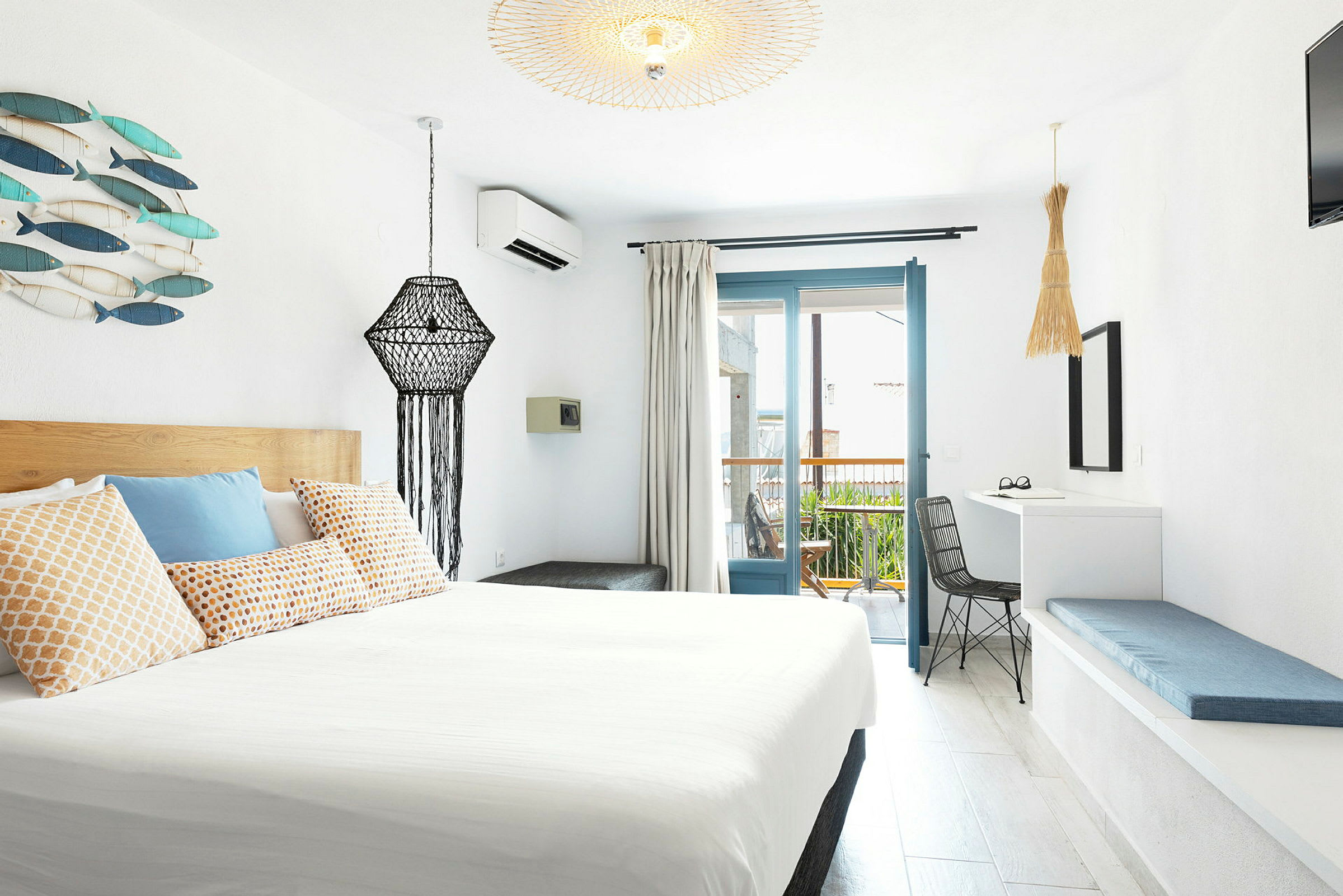 Et moderne innredet hotellrom med lys innredning og en balkong. (AI-generert tekst)