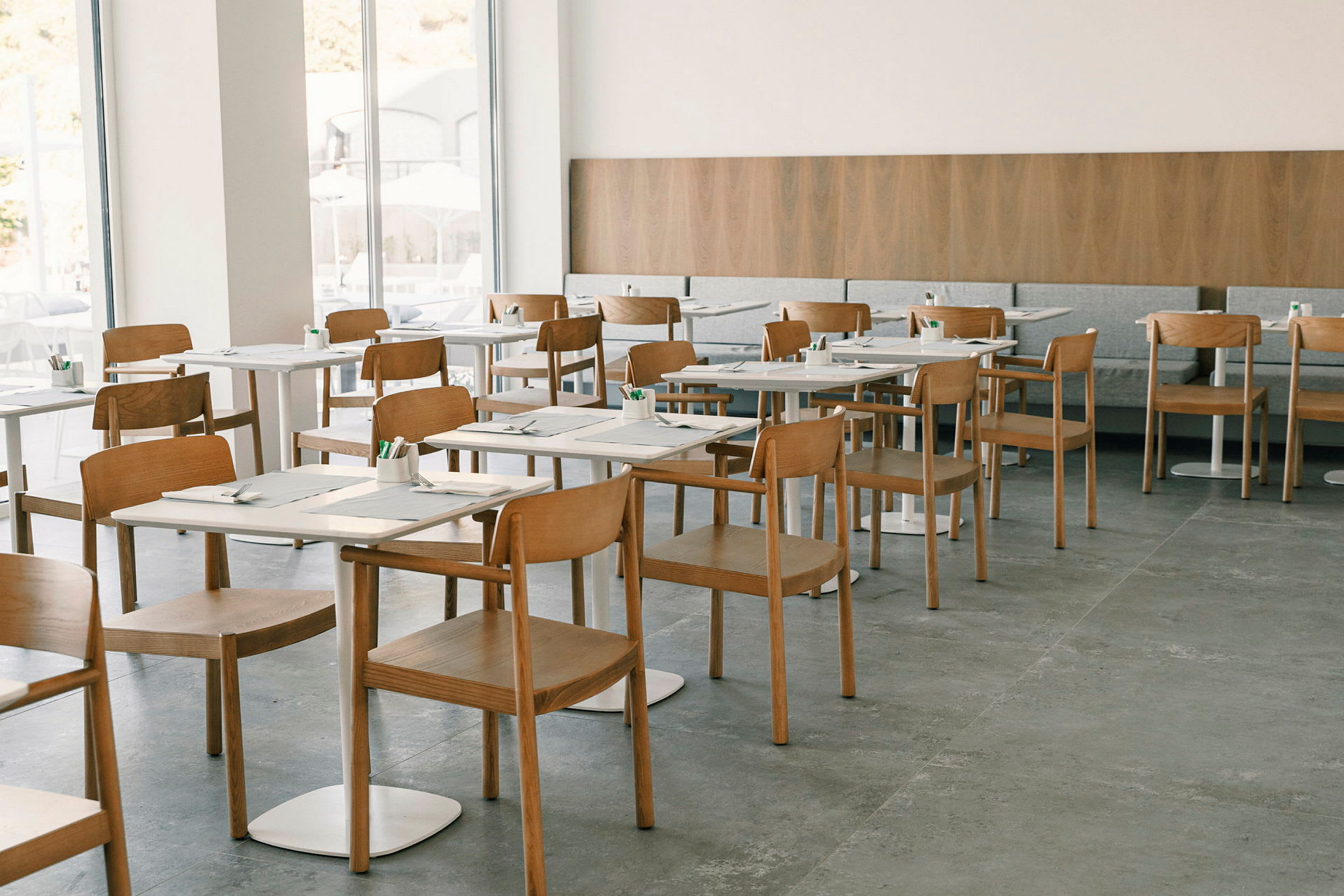 Restaurant med moderne trestoler og dekkede bord. (AI-generert tekst)