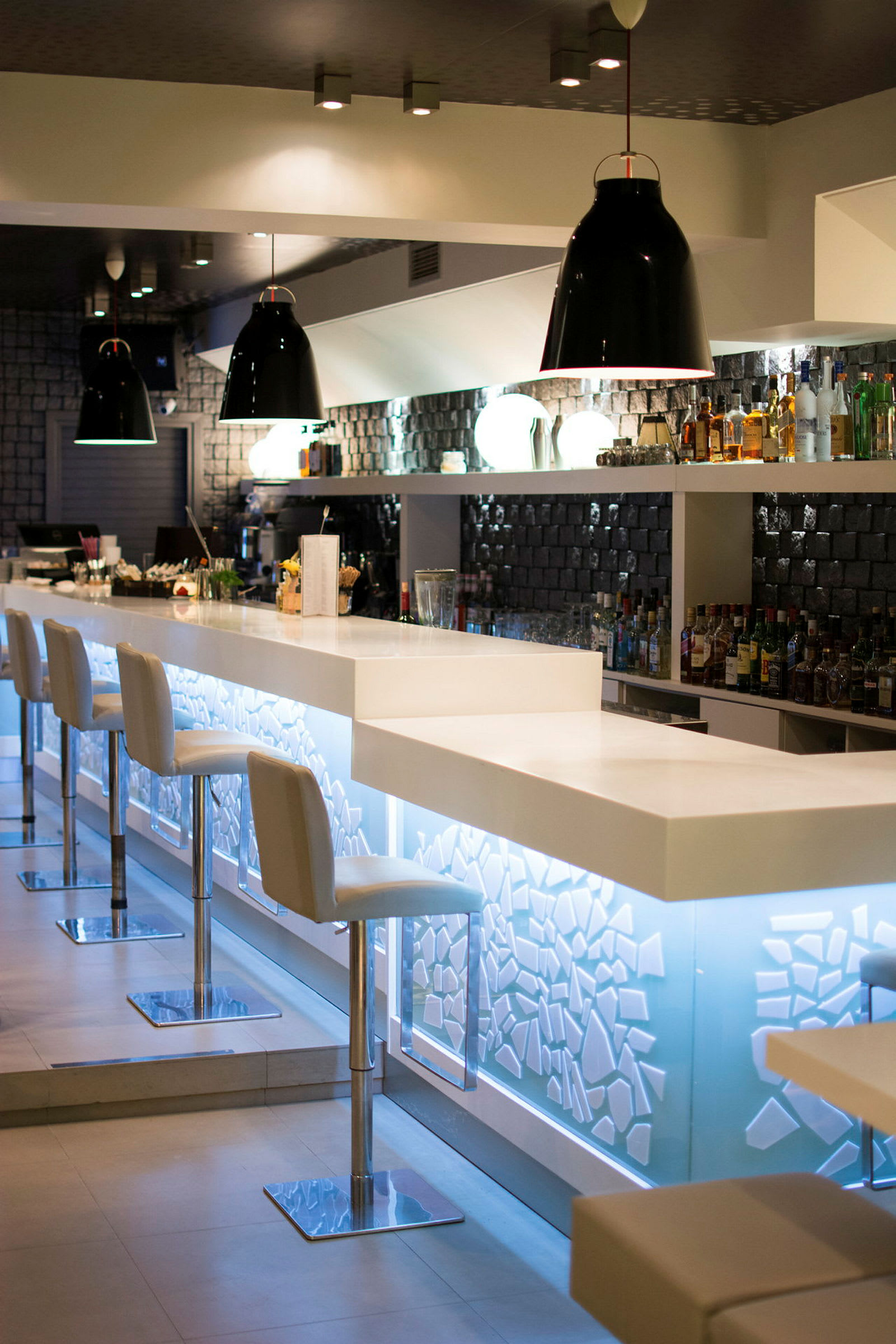 En moderne bar med hvite stoler og en opplyst bardisk. (AI-generert tekst)