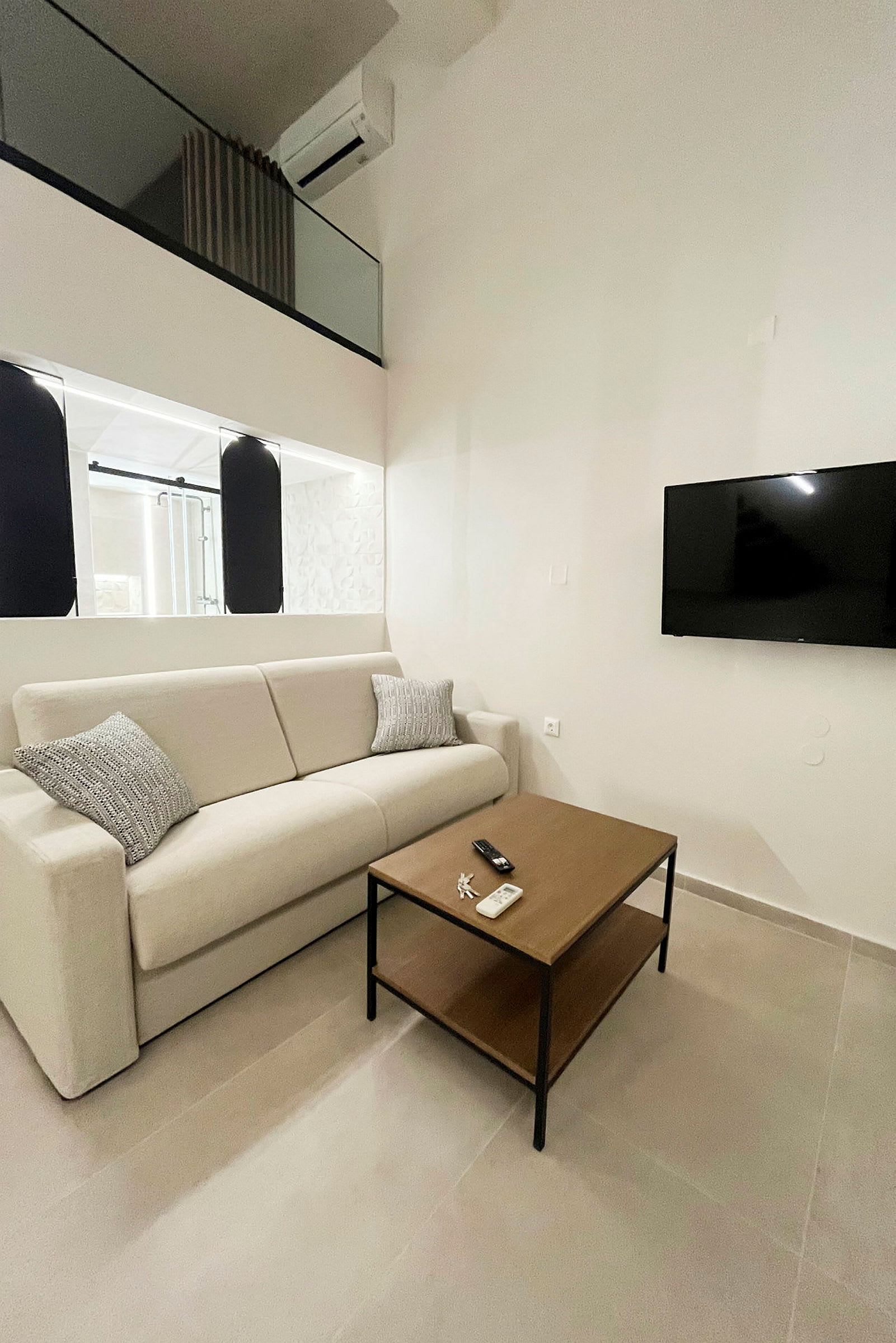 Bilde av et moderne rom med en beige sofa, et trebord og en veggmontert TV. (AI-generert tekst)