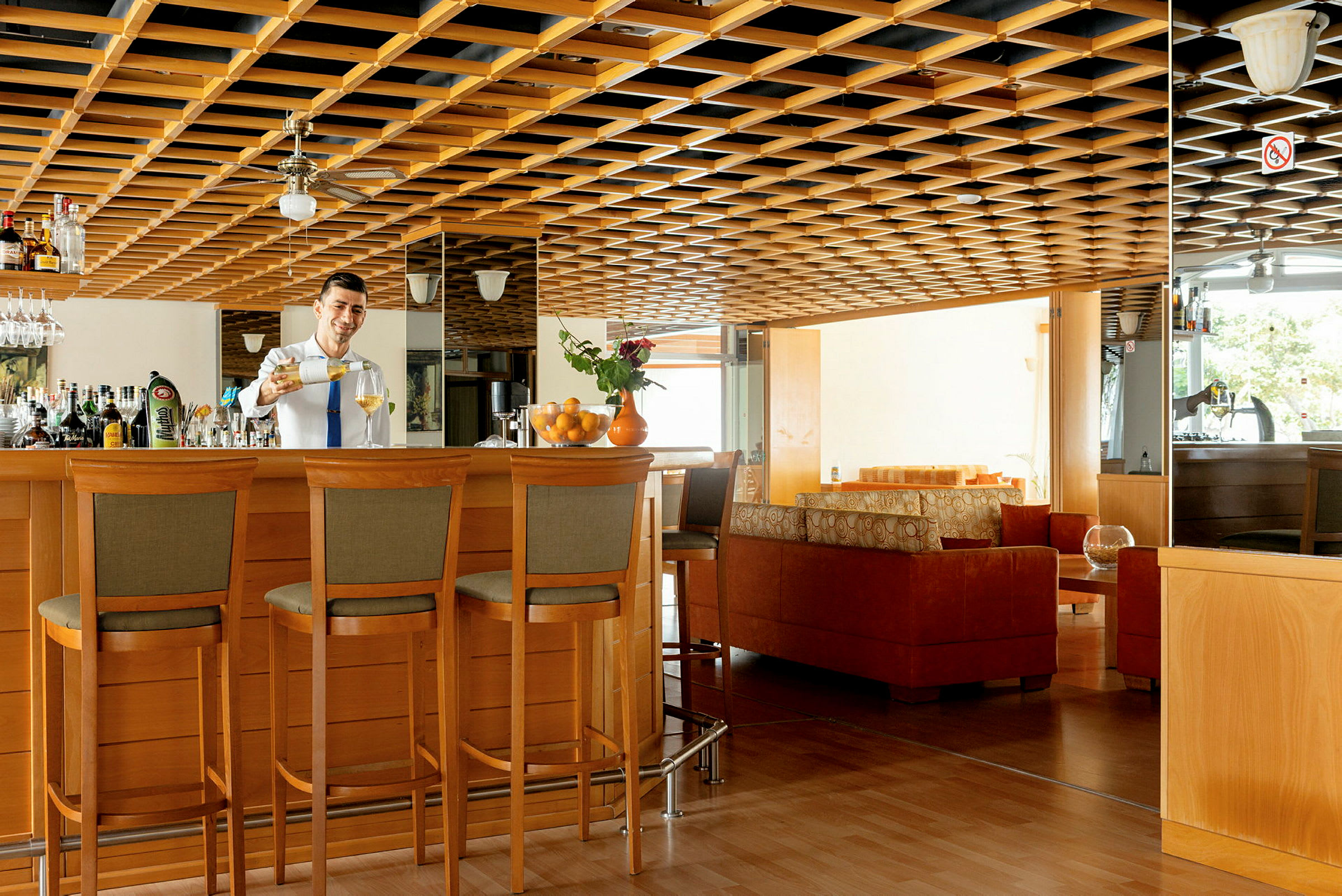 Moderne innredet hotellbar med tredetaljer og sittegrupper. (AI-generert tekst)