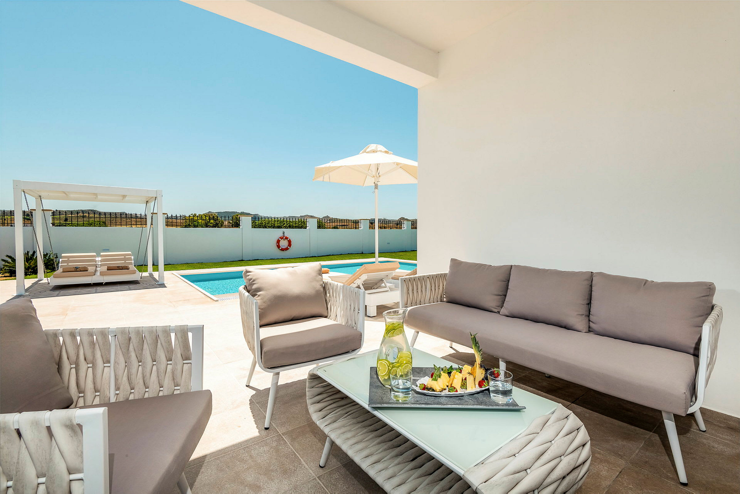 Bilde av en terrasse med utemøbler, et basseng og en pergola i bakgrunnen. (AI-generert tekst)