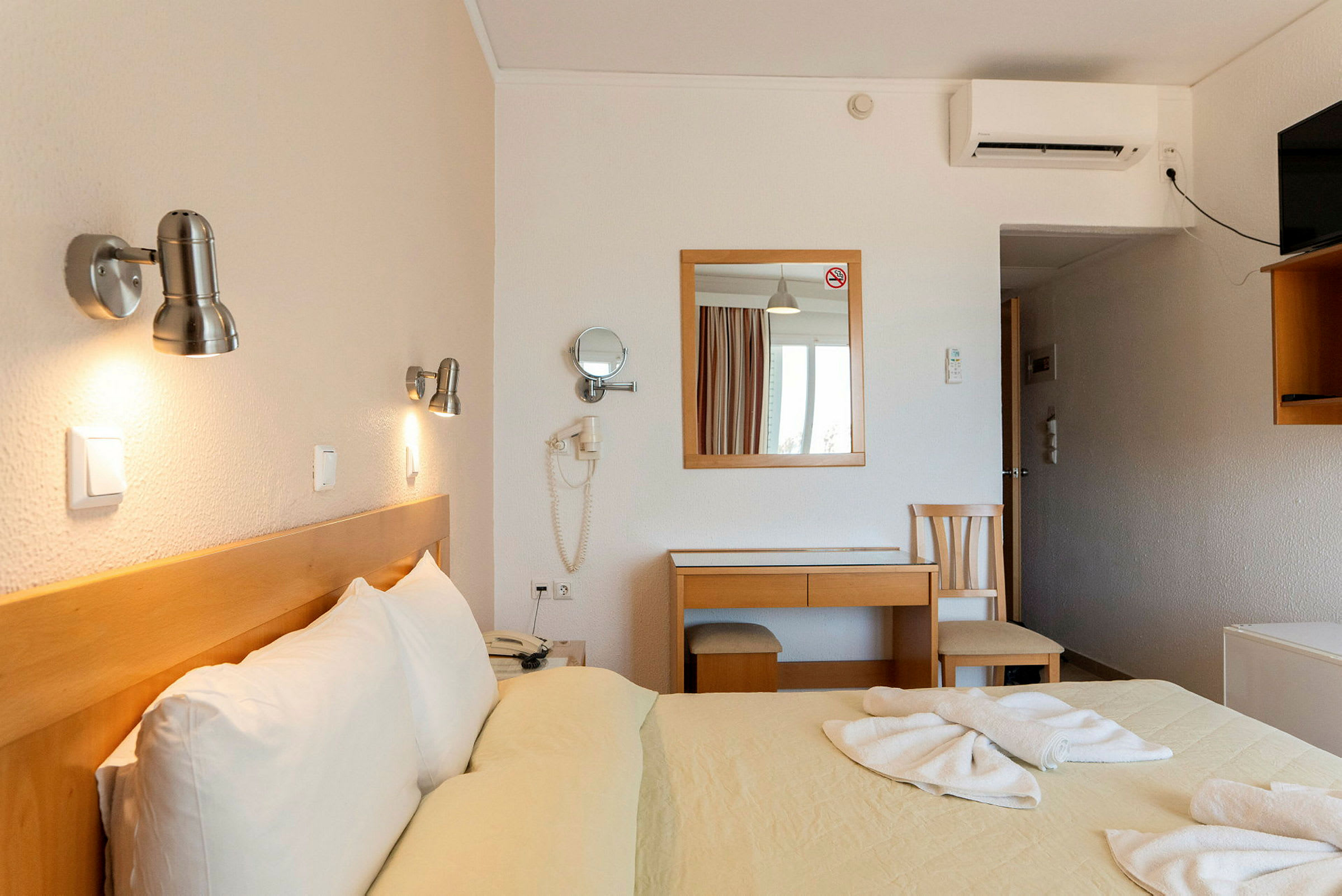 Hotellrom med dobbeltseng og skrivebord. (AI-generert tekst)
