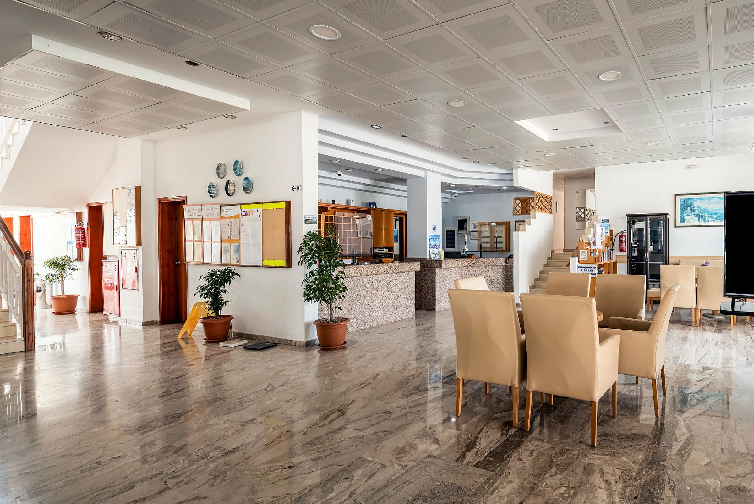 Interiør av et hotell. Lys lobby med marmorgulv og sitteplasser. (AI-generert tekst)