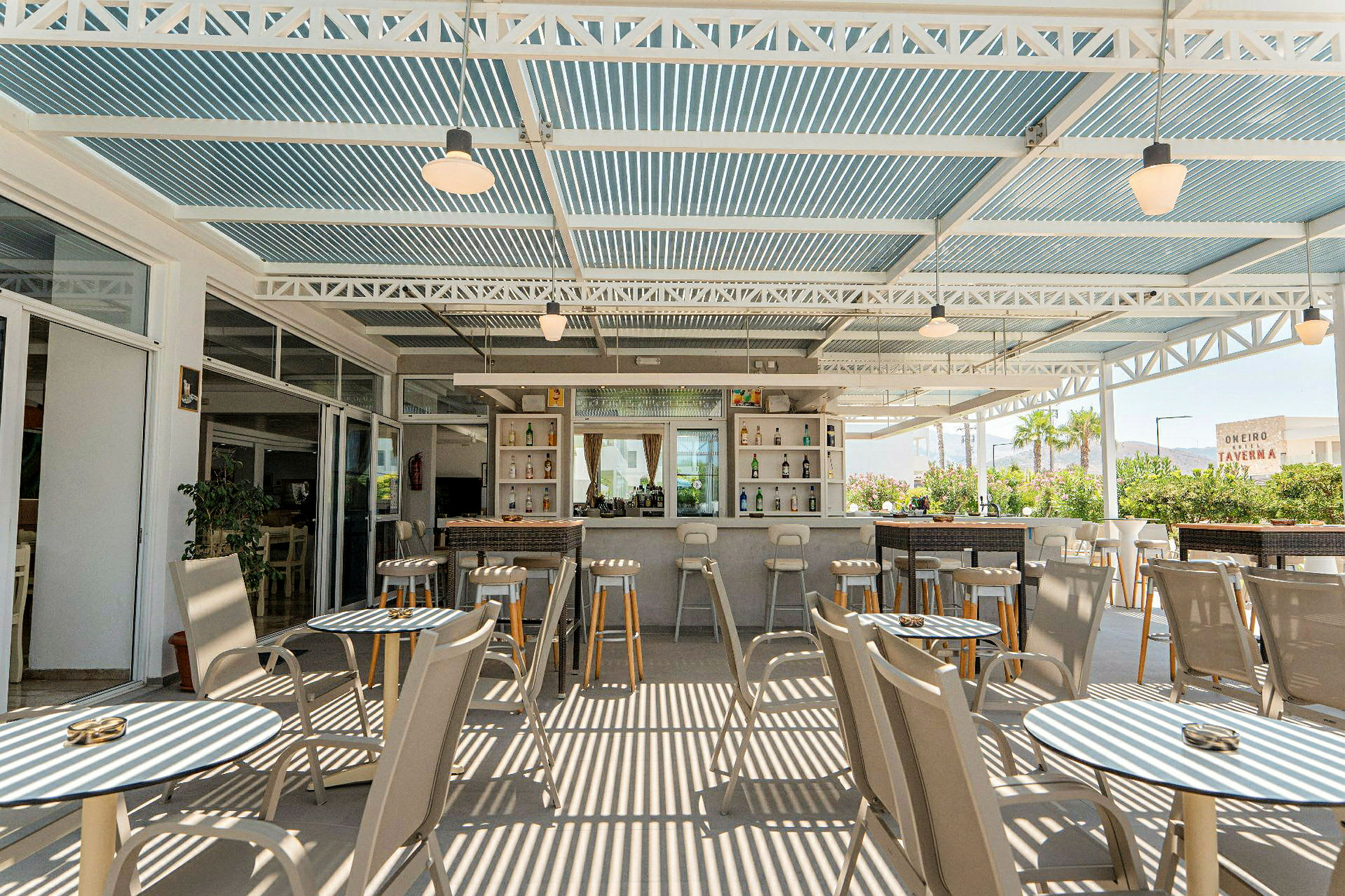 Terrasse med bord og stoler samt en bar. (AI-generert tekst)