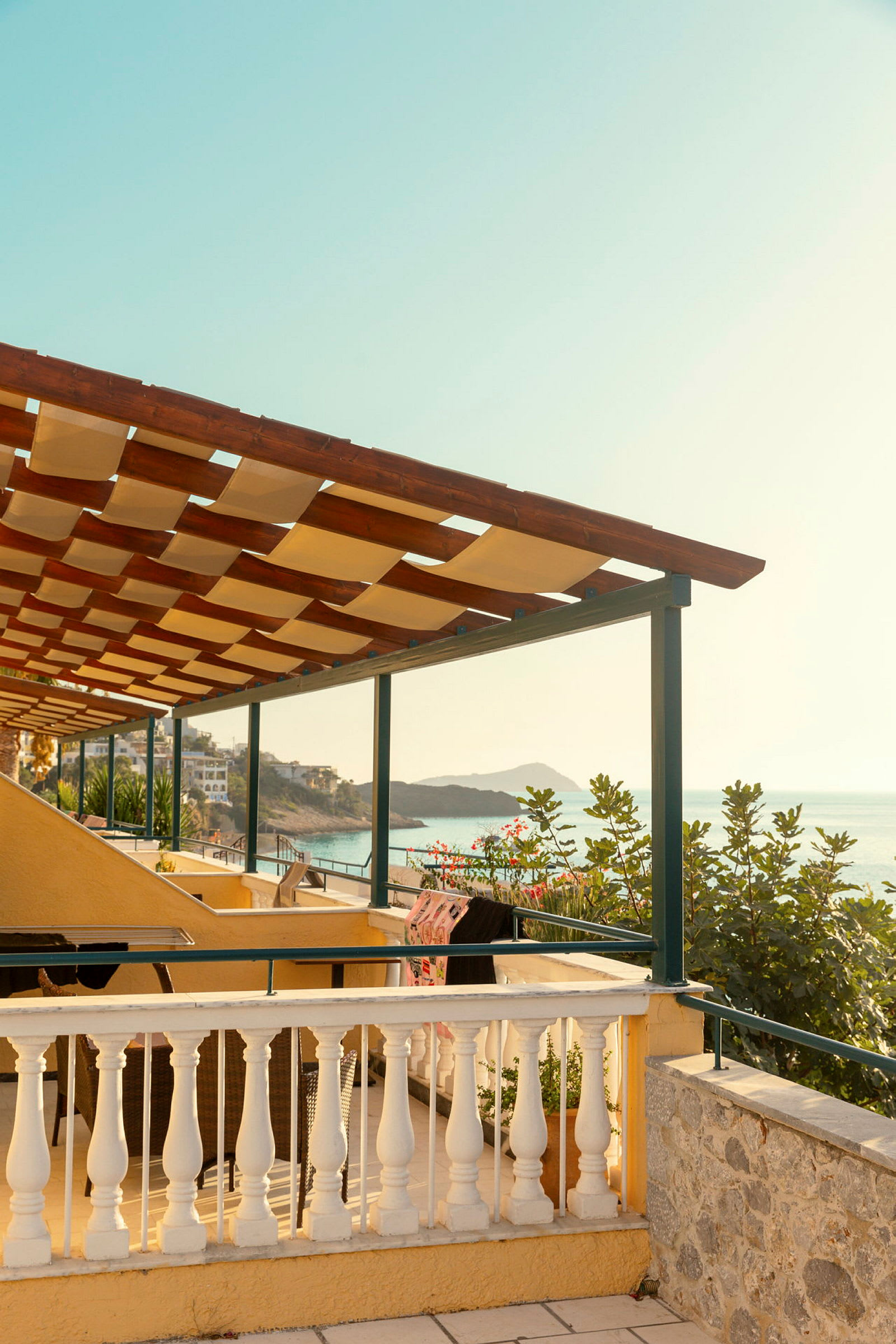 Utsikt fra en terrasse med pergola mot havet. (AI-generert tekst)