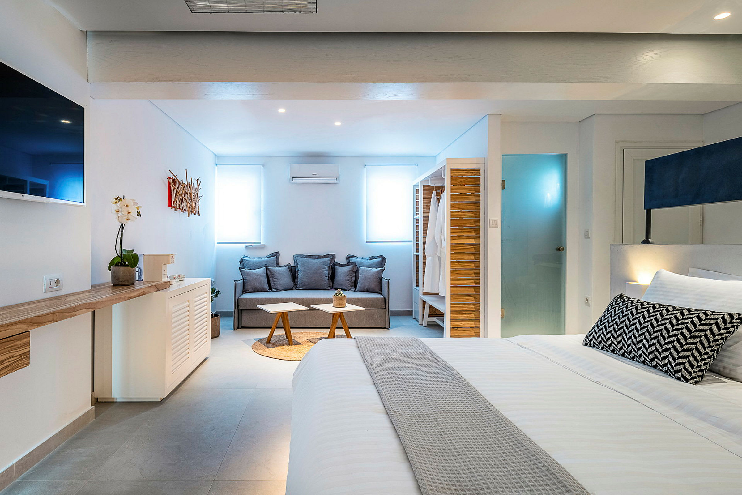 Moderne innredet hotellrom med sofa og seng. (AI-generert tekst)