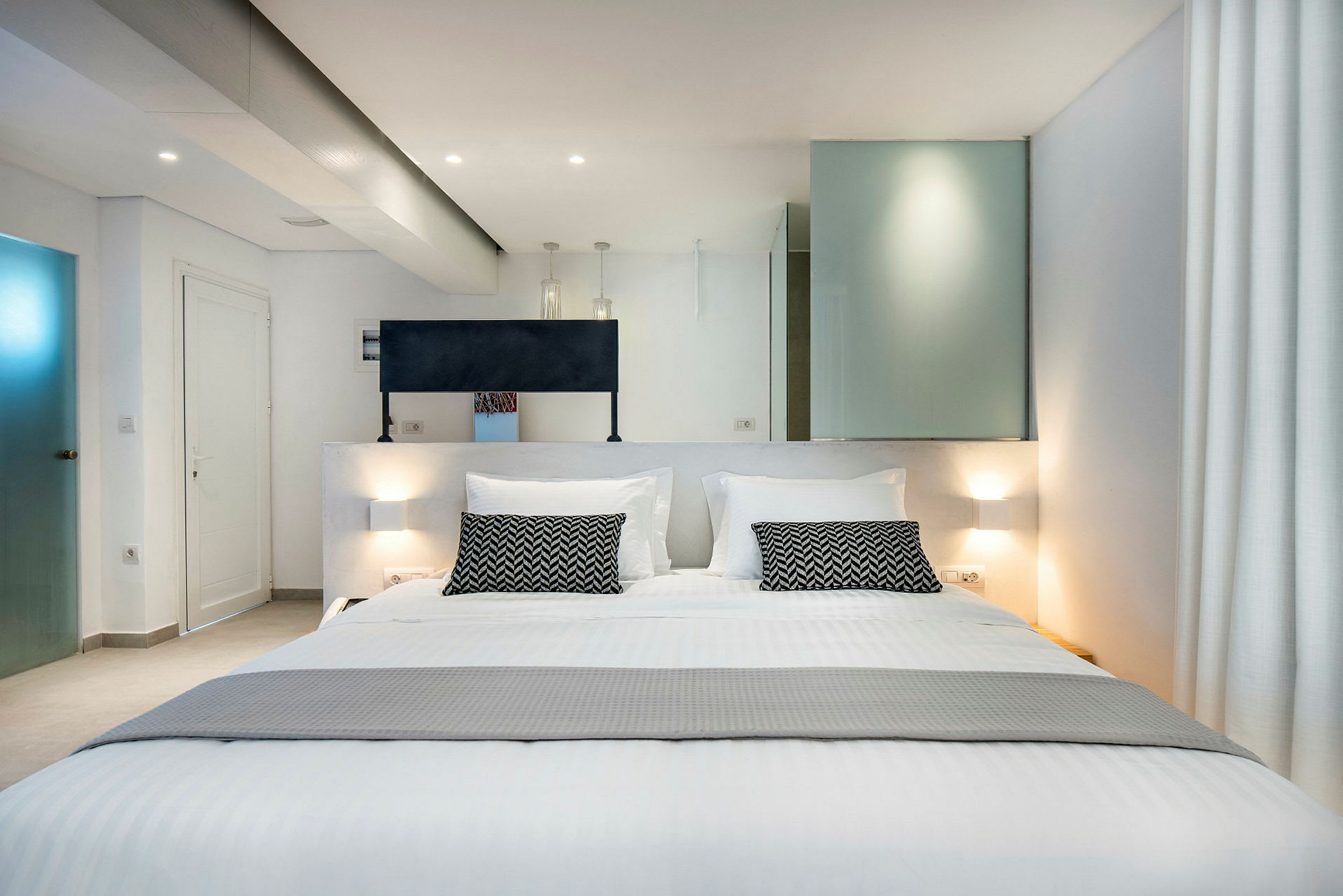 Et moderne hotellrom med en stor dobbeltseng og elegante interiørdetaljer. (AI-generert tekst)