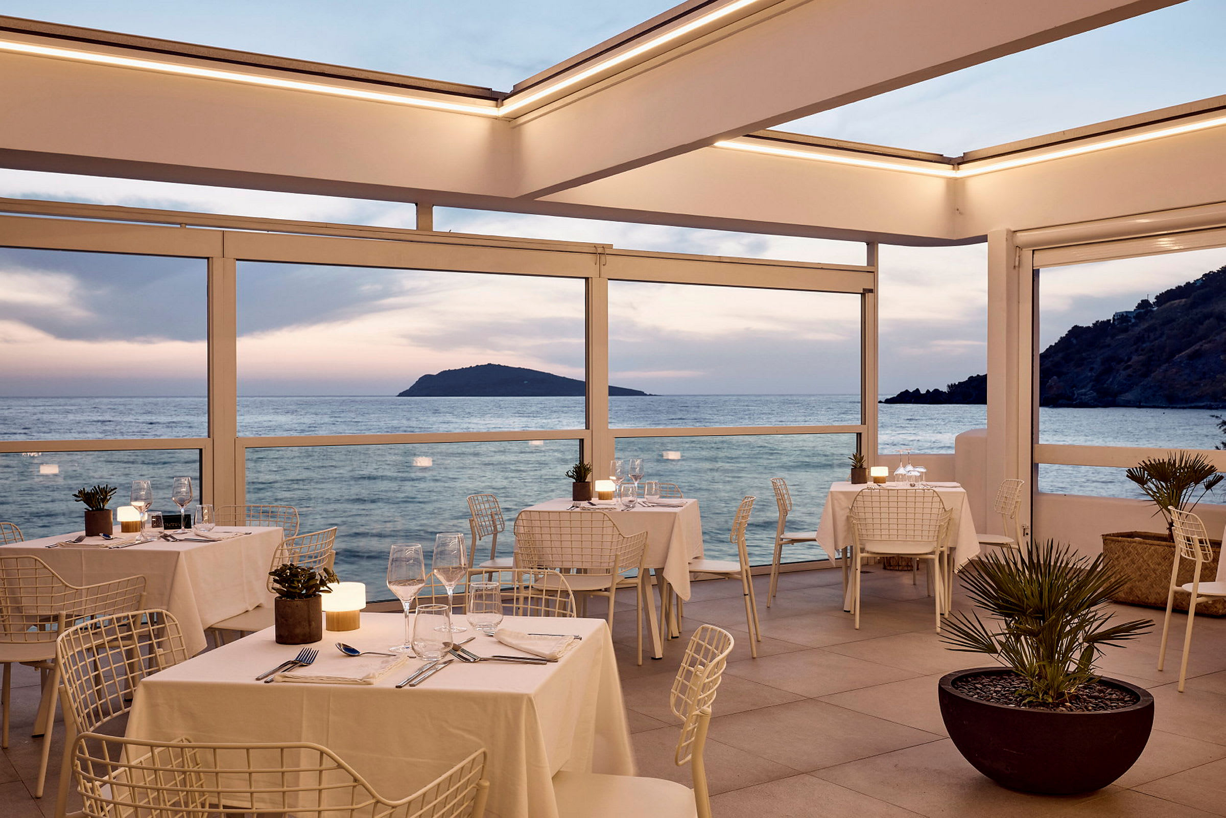 Restaurant med havutsikt under solnedgangen. (AI-generert tekst)