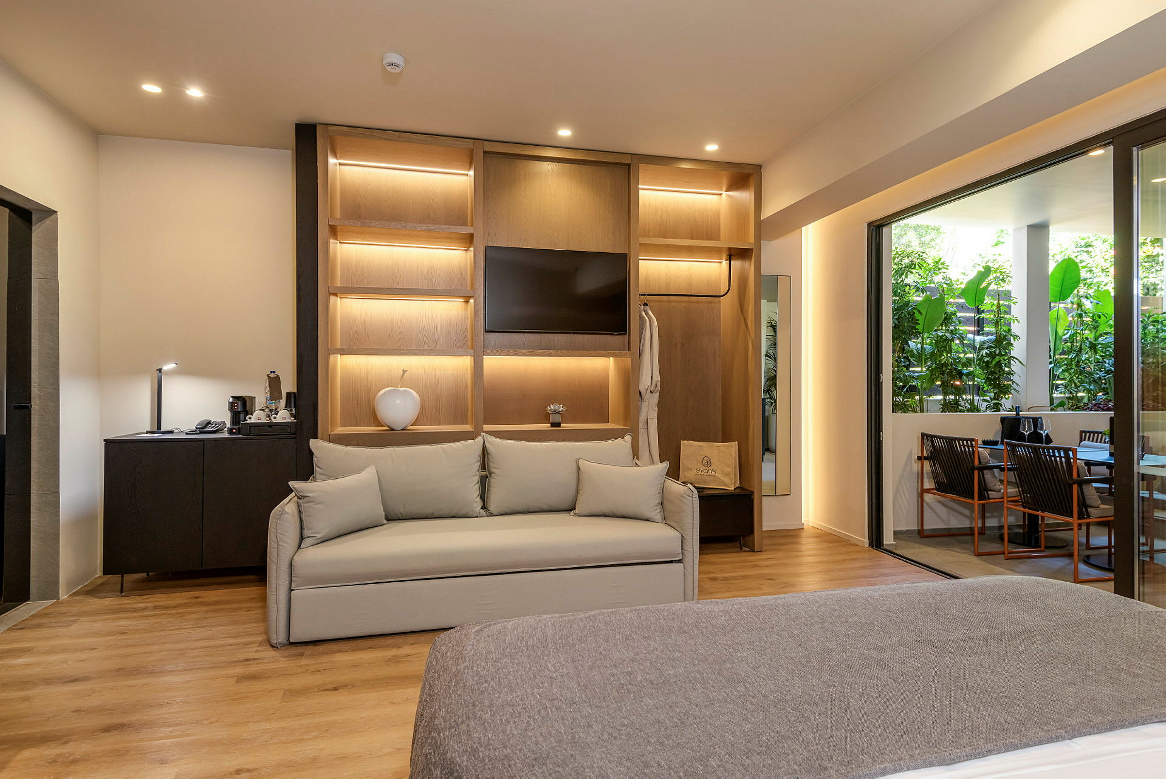Et moderne hotellrom med sofa, innebygd TV og balkongutsikt. (AI-generert tekst)
