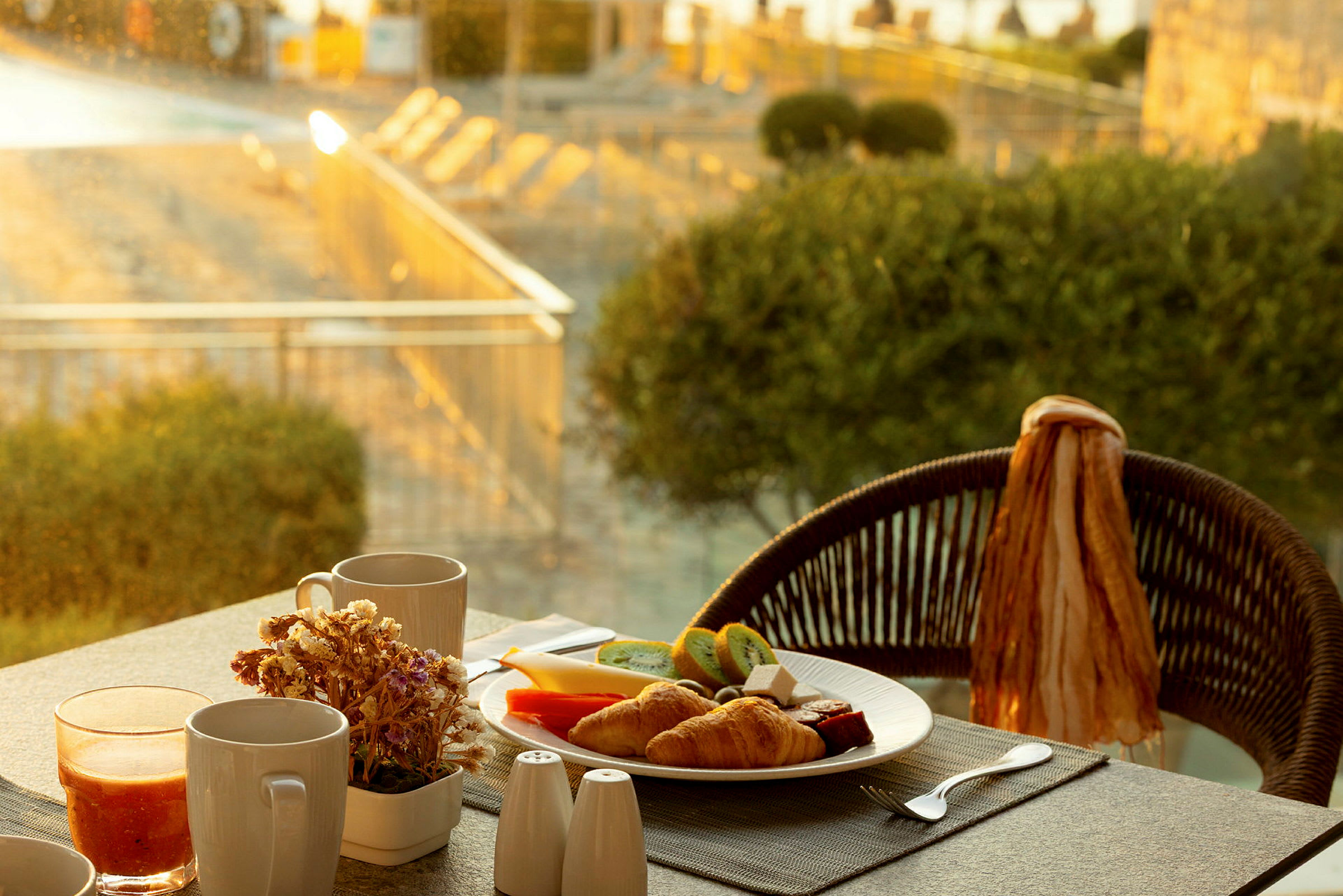 Tallerken med frokostmat og drikke på et bord med utsikt over en solrik hage. (AI-generert tekst)