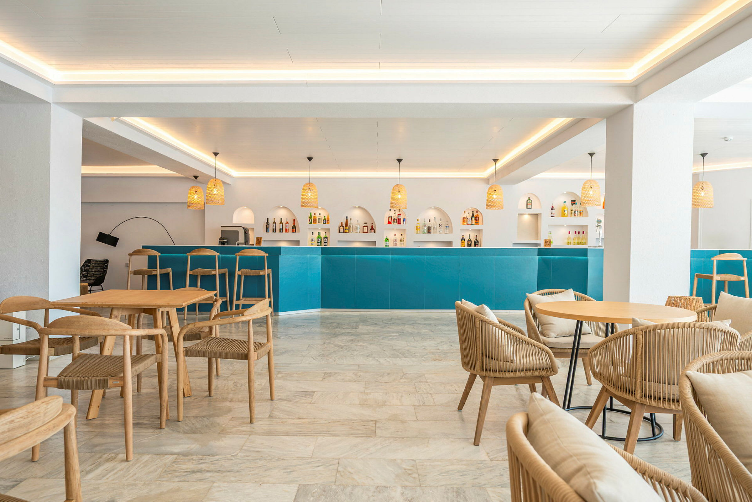 Bilde av en lys og moderne bar med blå disk, designstoler i tre og belysningsarmaturer. (AI-generert tekst)