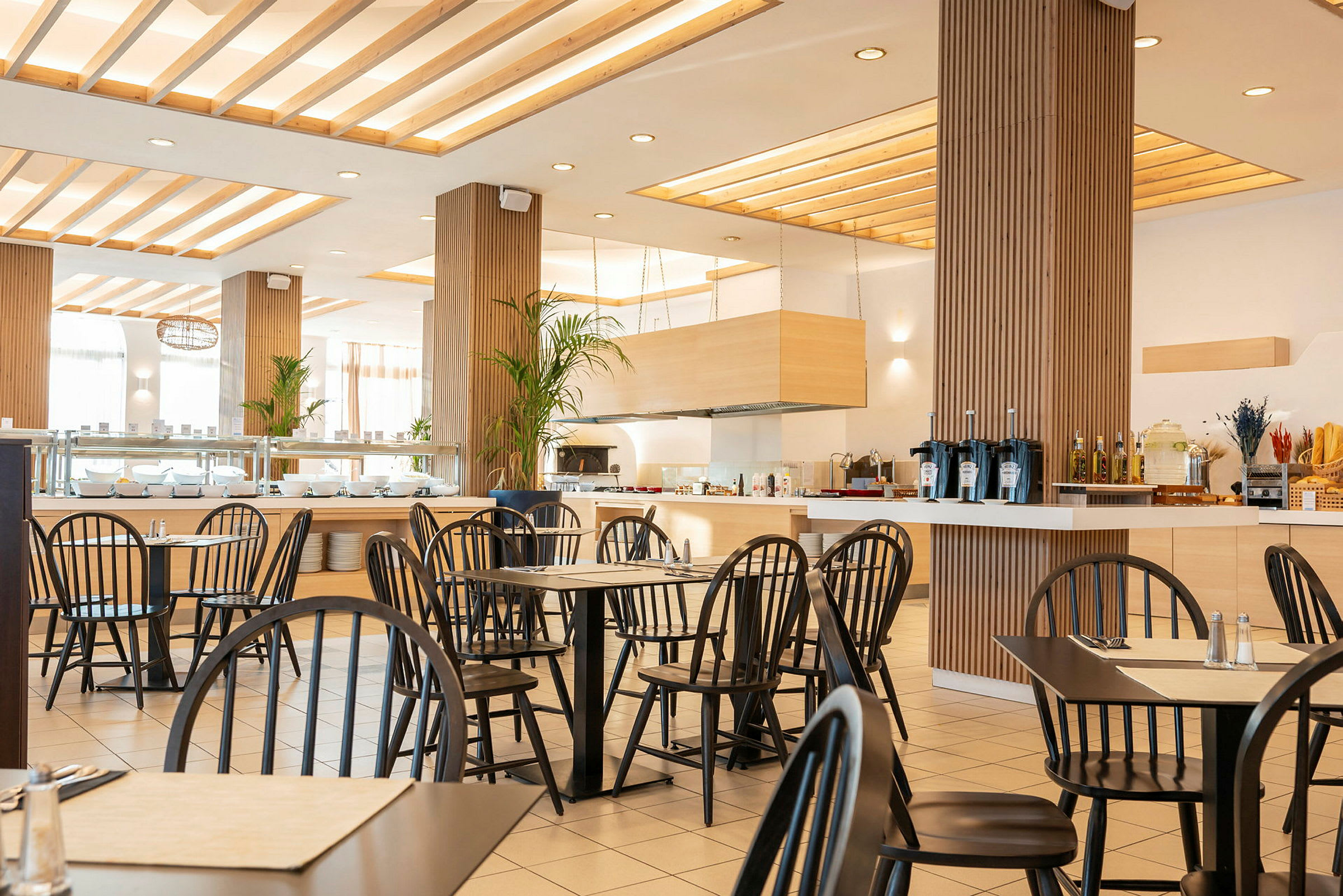En moderne restaurant med svarte stoler og lyst interiør. (AI-generert tekst)