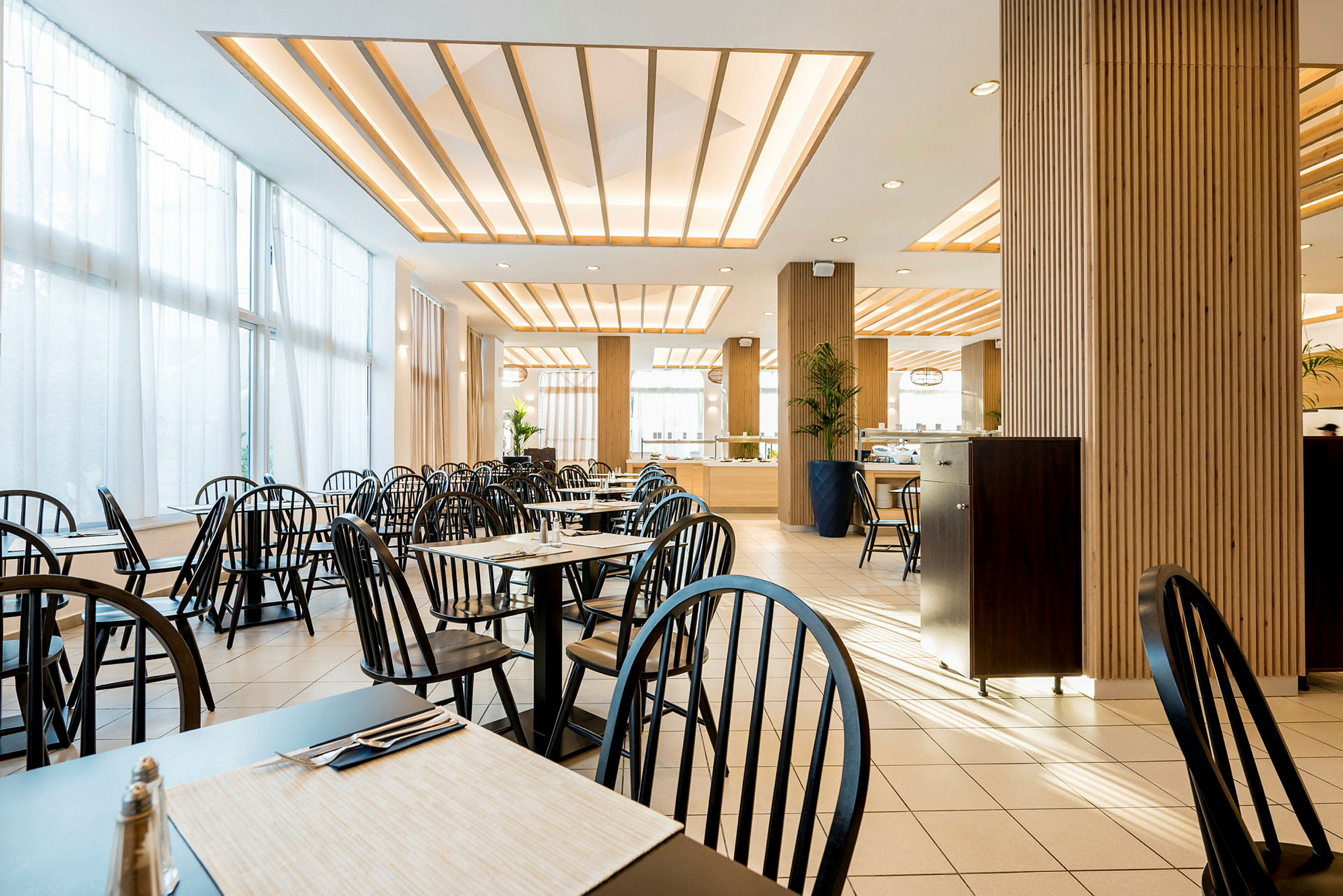 Restaurant med bord, stoler og moderne dekor. (AI-generert tekst)